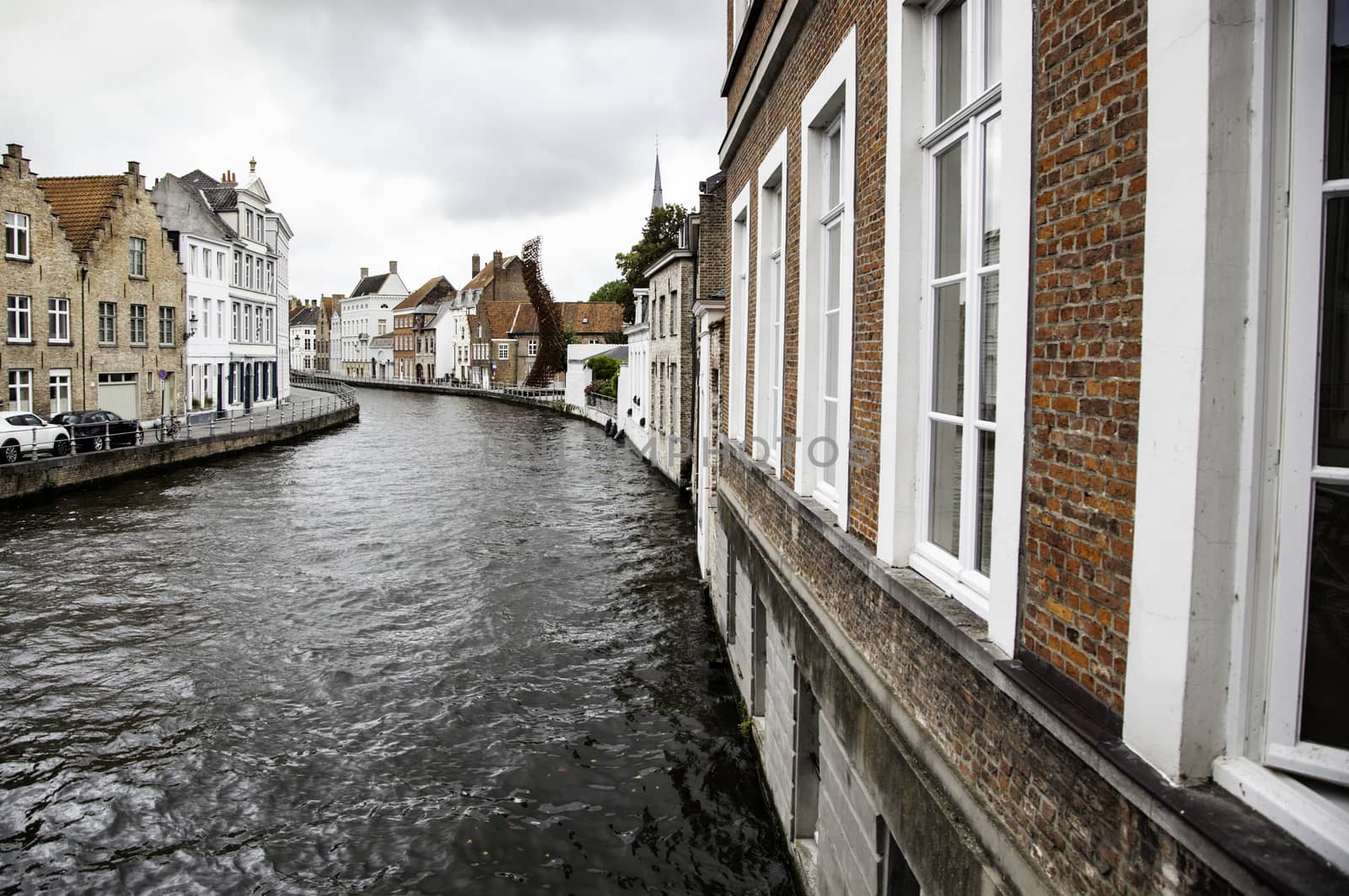 BRUGES, BELGIUM - SEPTEMBER 05, 2018: Canal in Bruges and famous Belfry tower on the background in a beautiful autumn day, Belgium on September 05, 2018