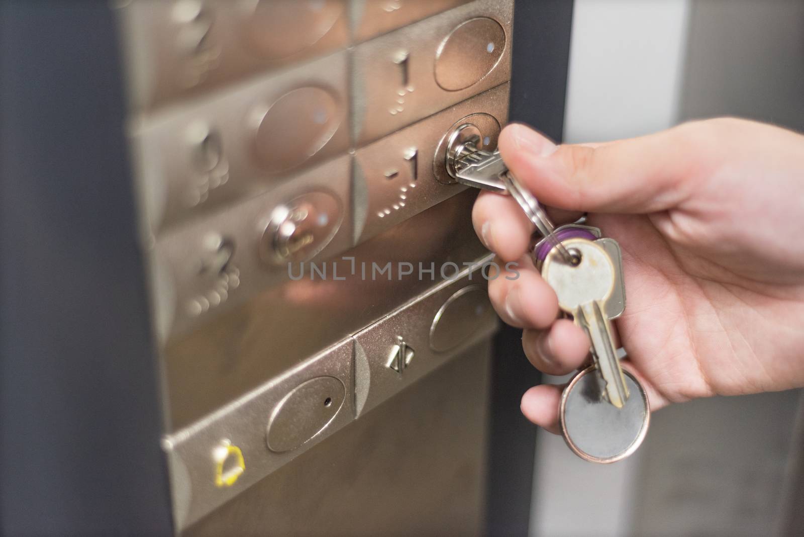 Elevator access control. hand holding a key to unlock elevator floor