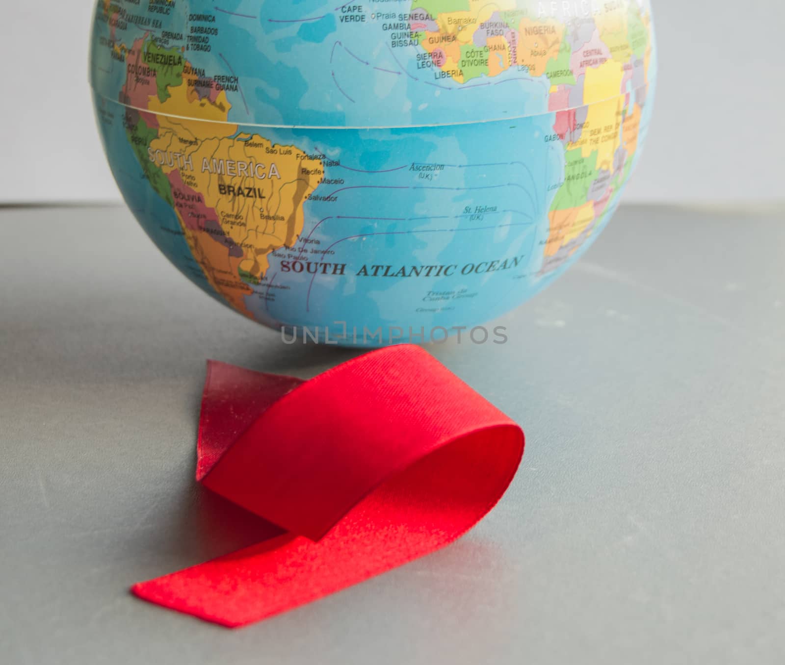 World AIDS day 1 December, close-up of world globe with red ribbon.