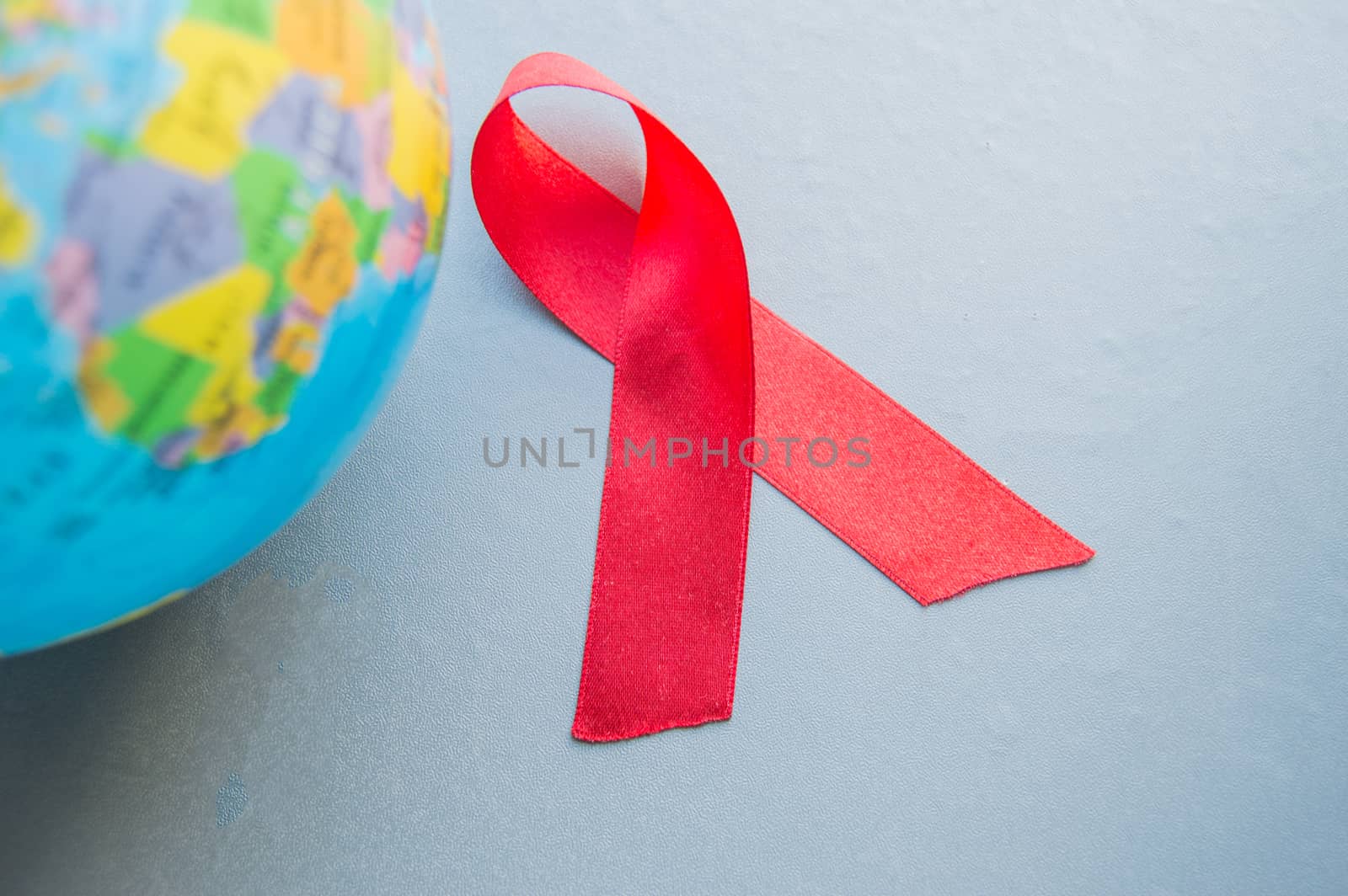 World AIDS day 1 December, close-up of world globe with red ribbon by claire_lucia