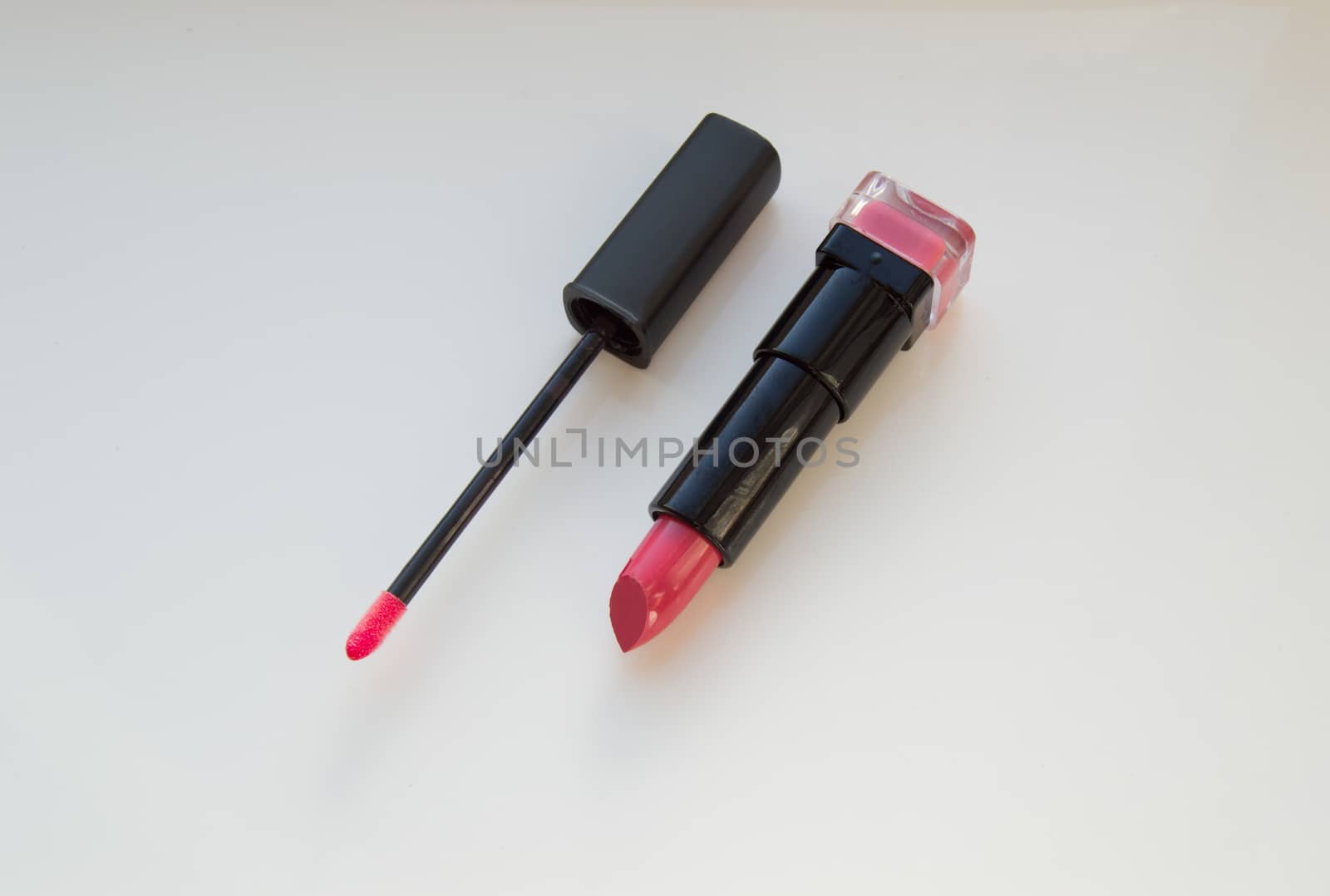 brush for lipgloss, lipstick red, pink on white background.