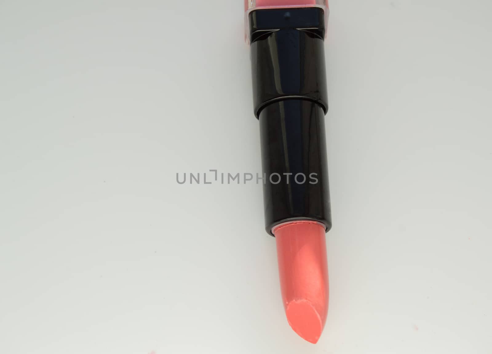 Pink lipstick, open the tube on a white background.