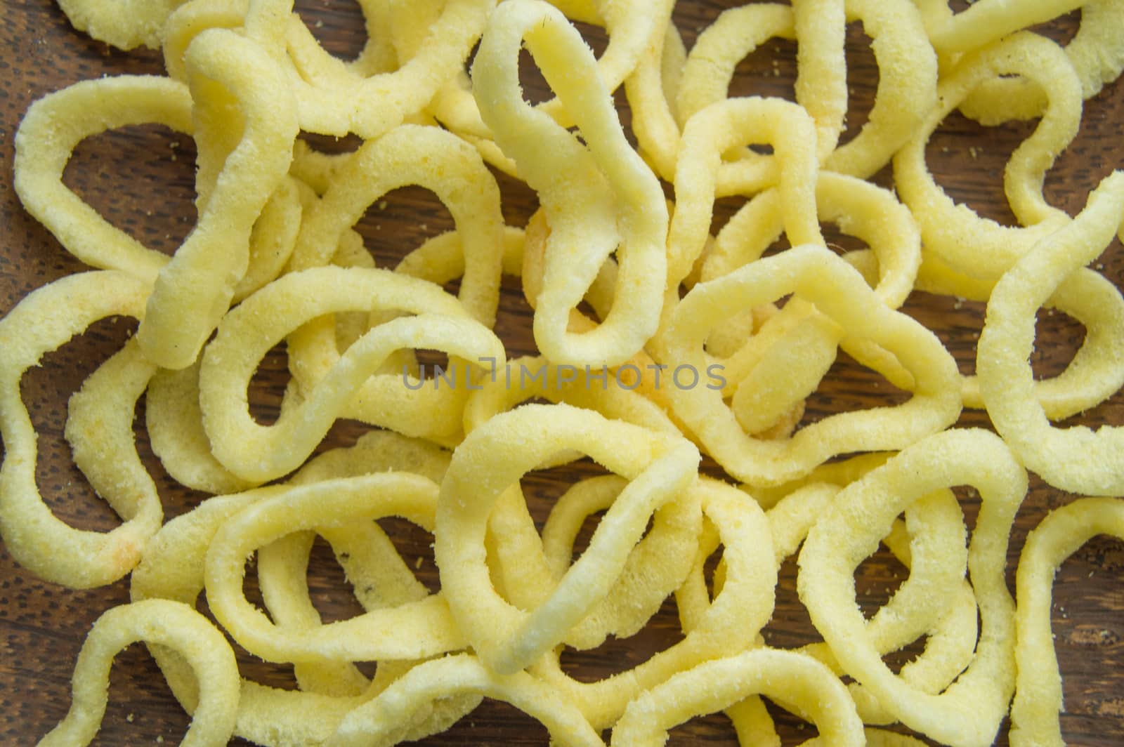 Onion rings on a dark wooden dish background, close-up, top view