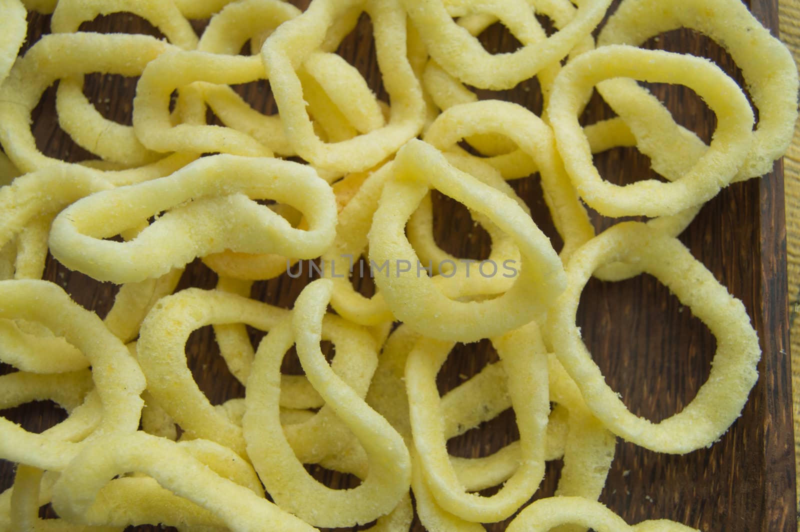 Onion rings on a dark wooden dish background, close-up, top view