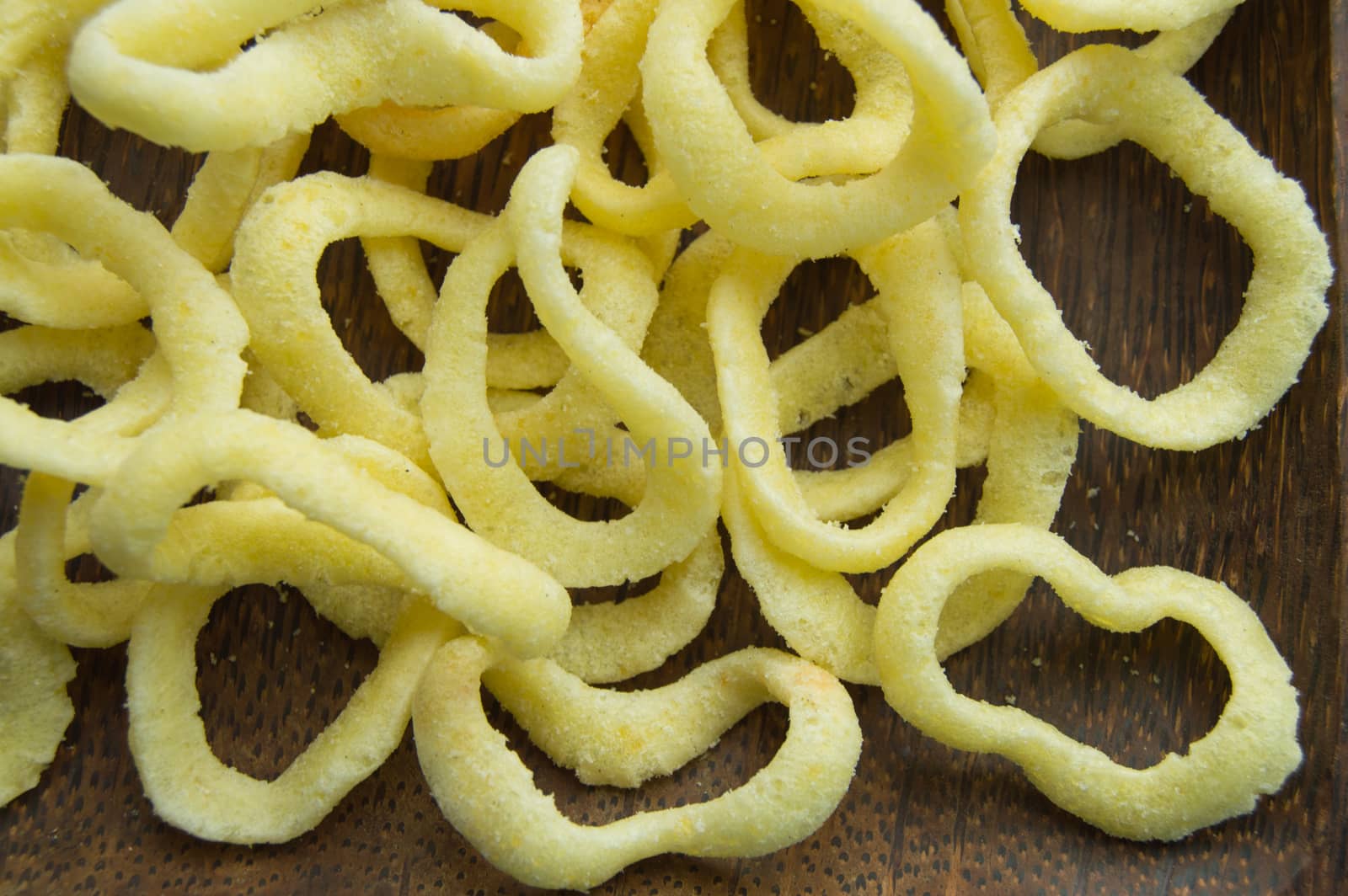 Onion rings on a dark wooden dish background, close-up, top view