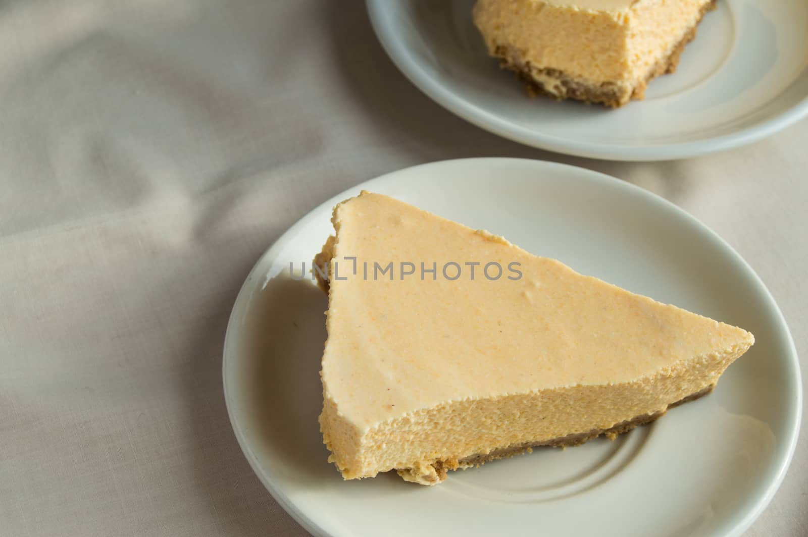 delicious piece of cheesecake on a white plate is on the table with a napkin
