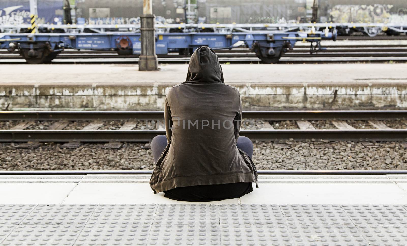 Woman sitting in a train station by esebene