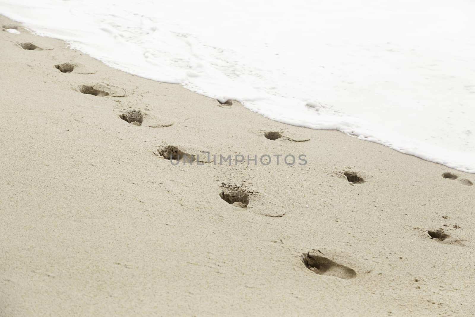 Footprints in the sand beach, detail marks at sea