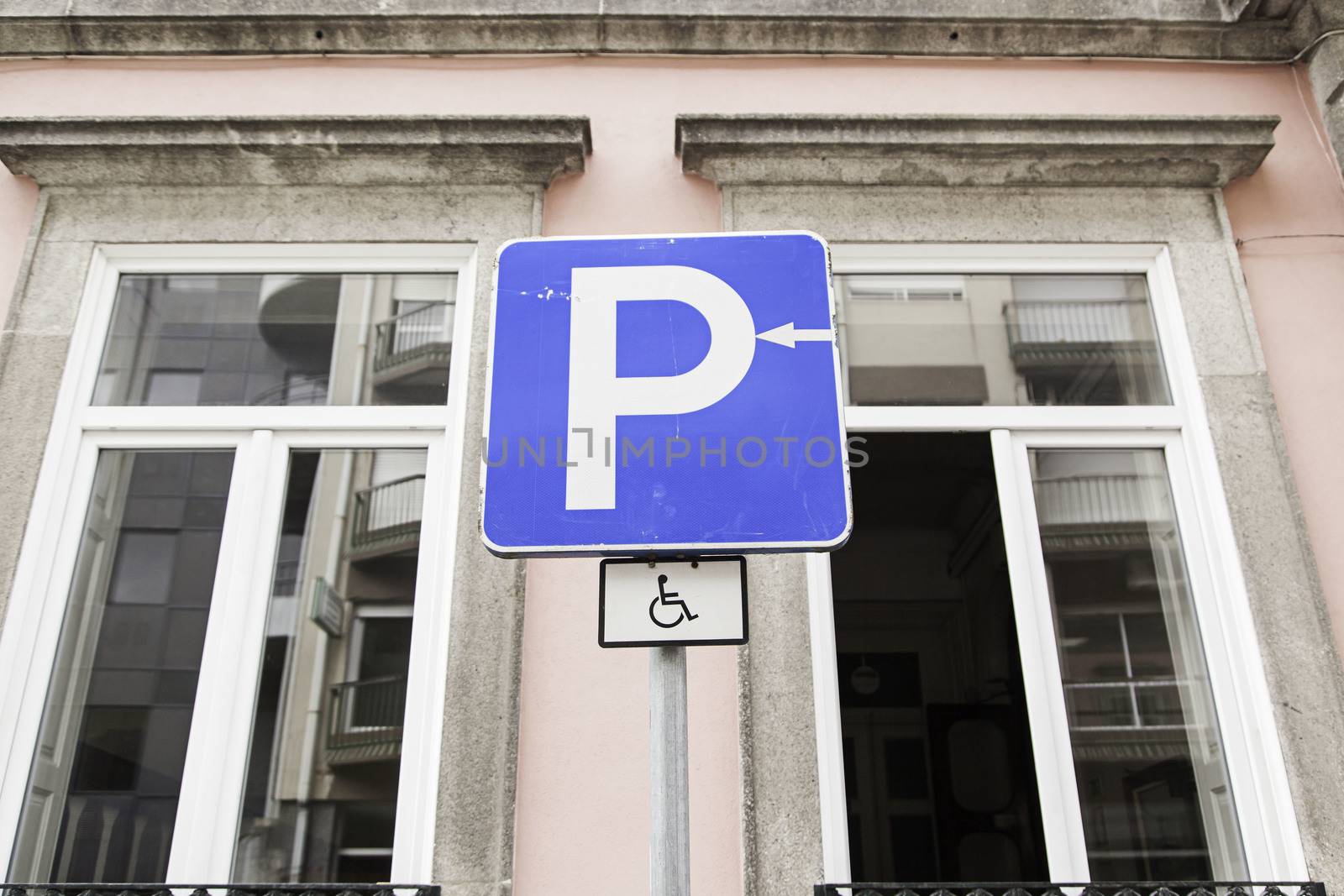 Handicapped parking sign in urban street, symbol
