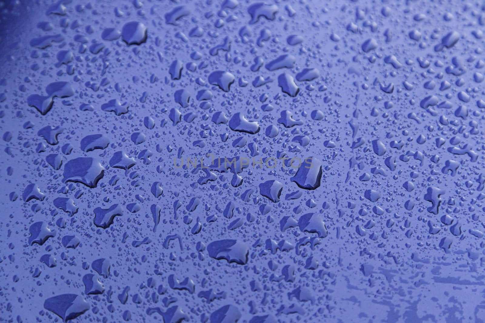Rain drops, detail of a wet blue background, cold and texture