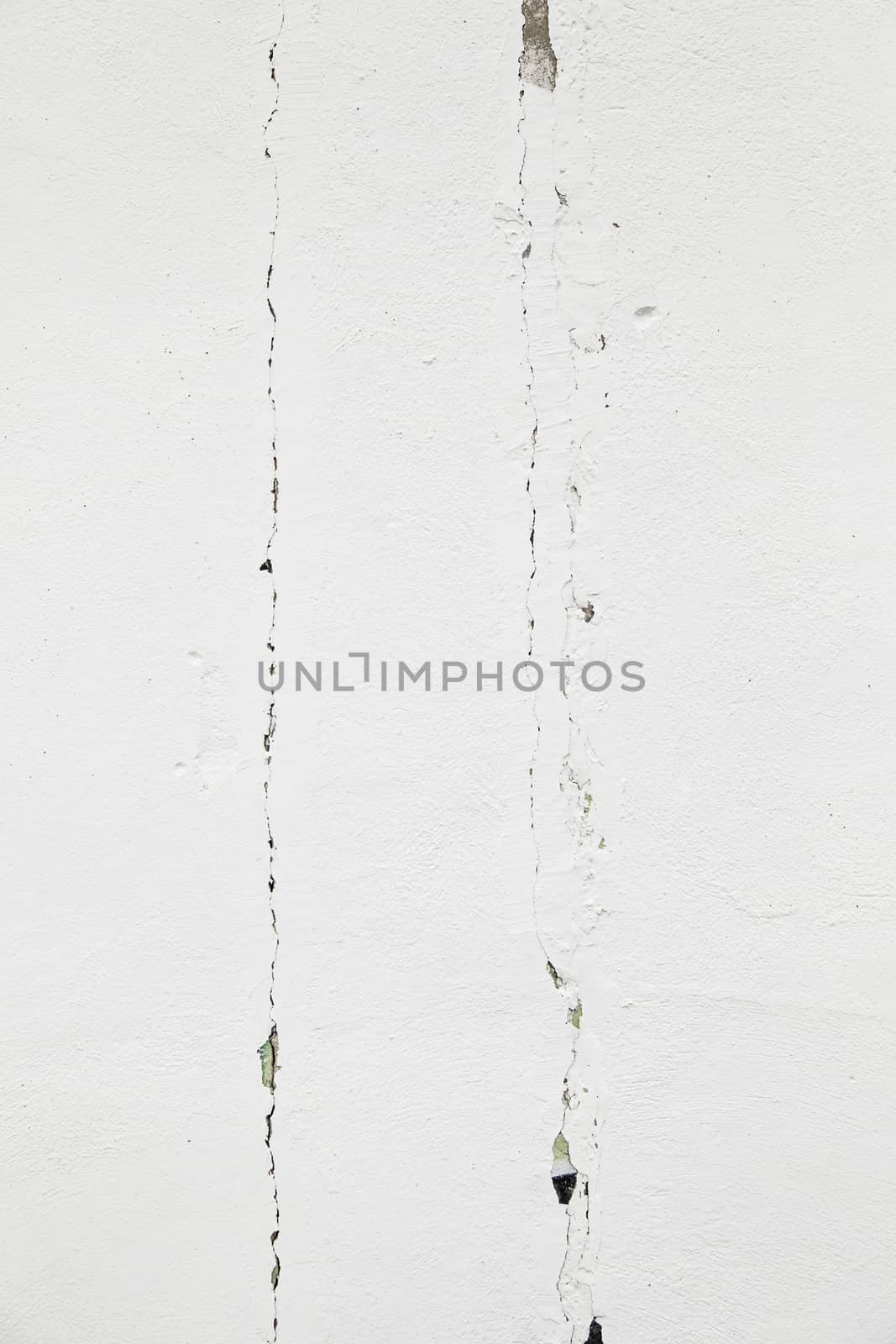 White wall with cracks, detail of a deteriorated wall, textured background