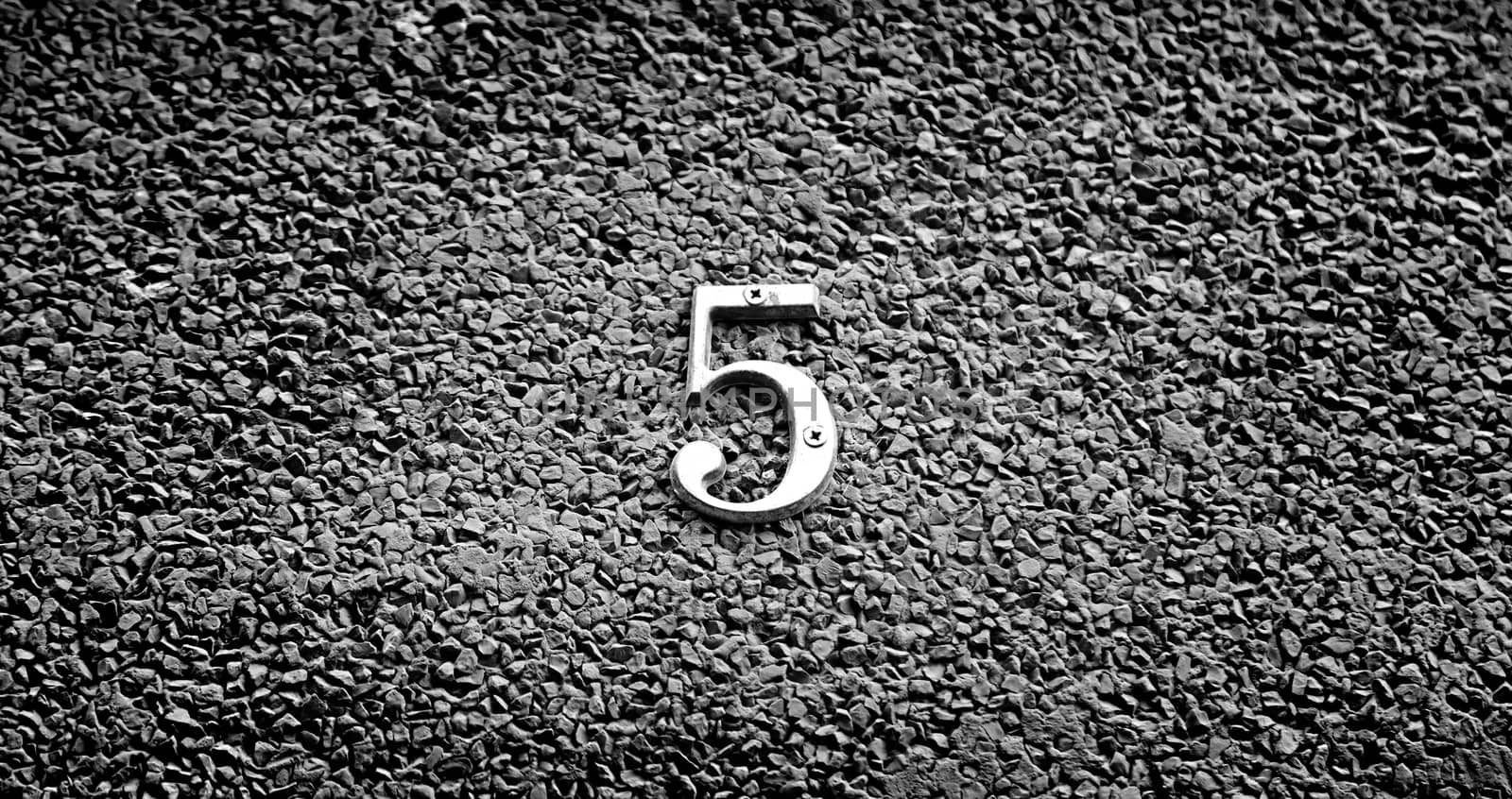 Number five on the wall of a house, detail of a number of information, odd number