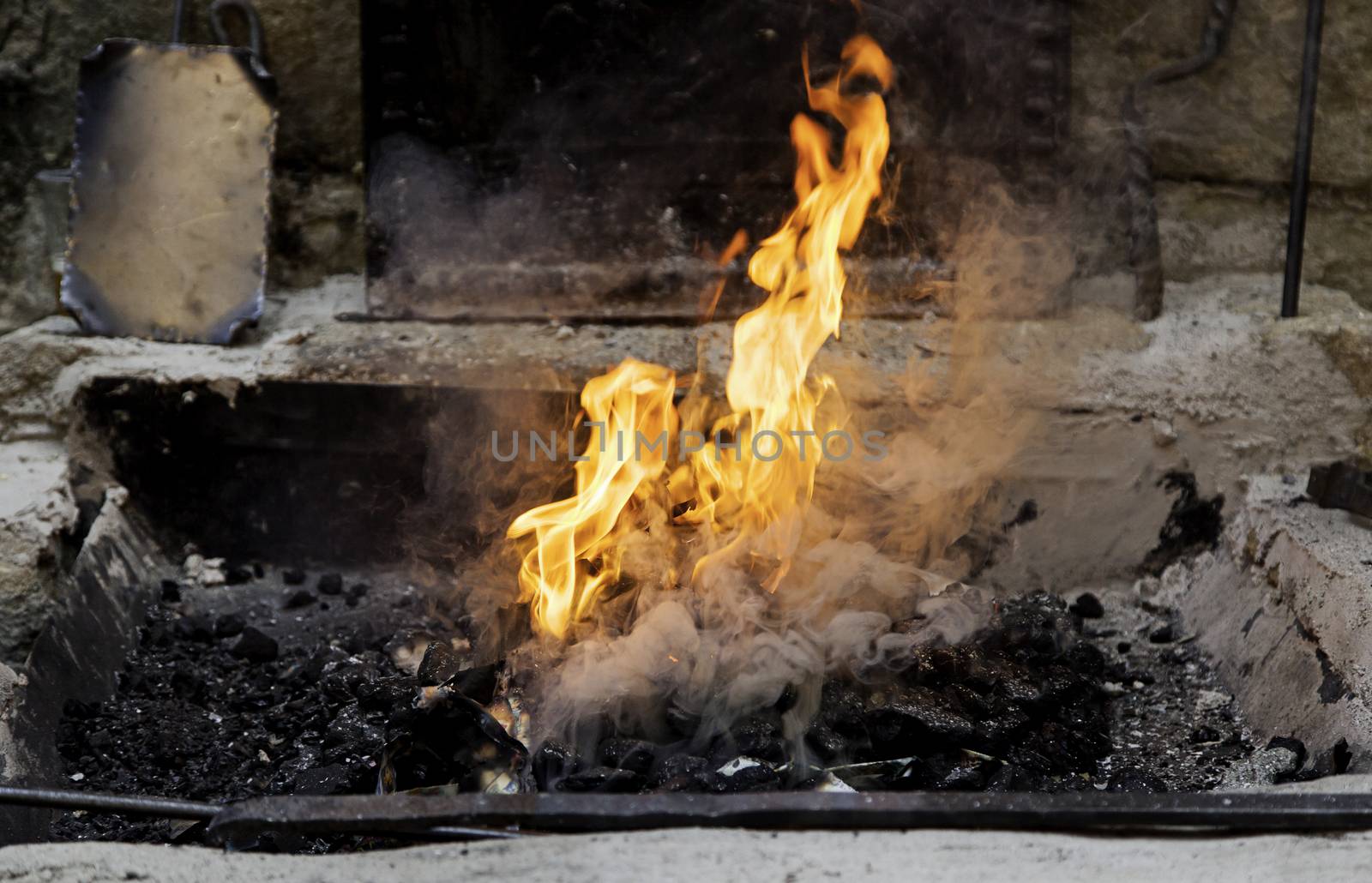 Carbon fire in a forge, detail of a workshop with iron