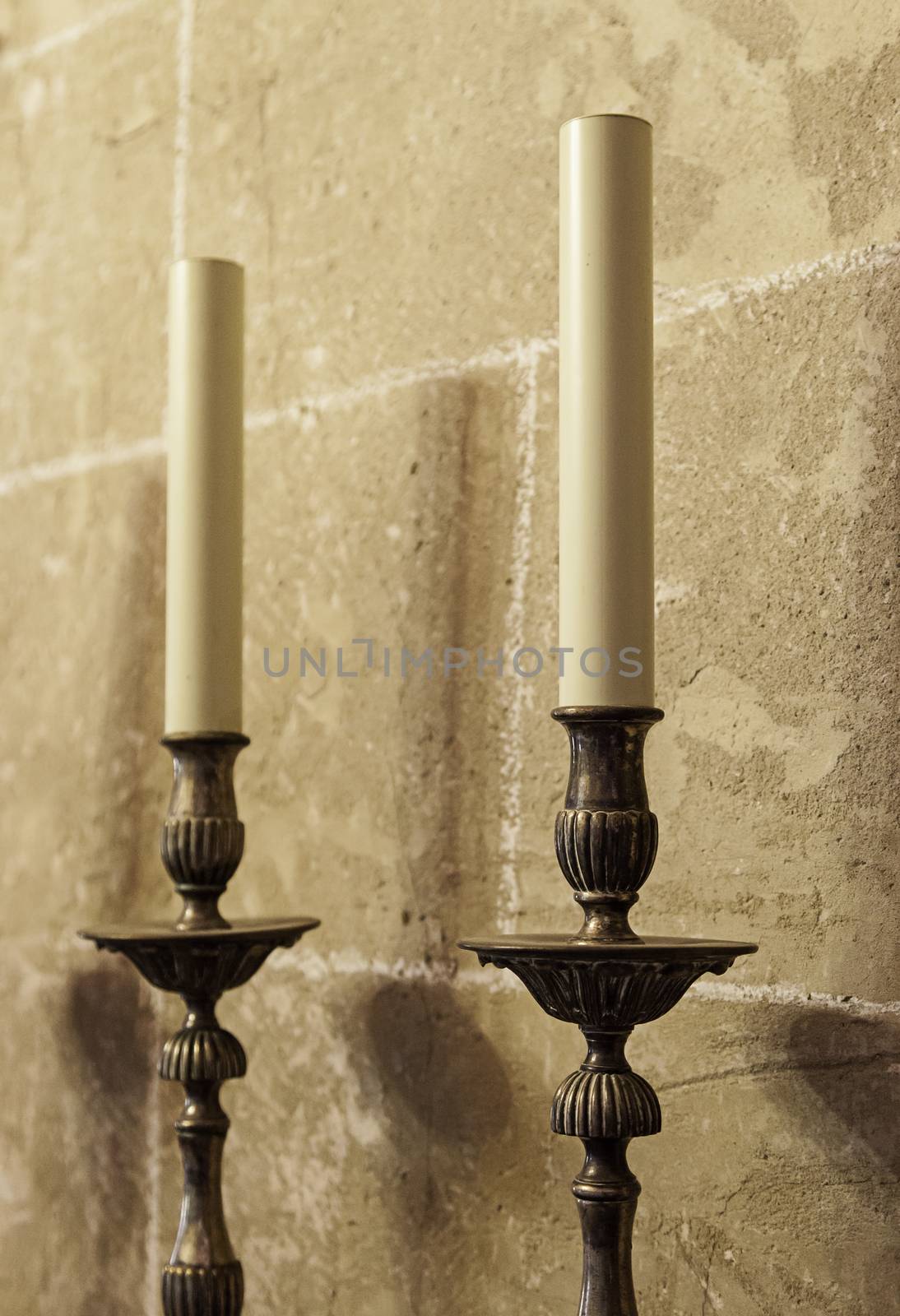 Old medieval candelabrum with wax candles, detail of lighting instrument
