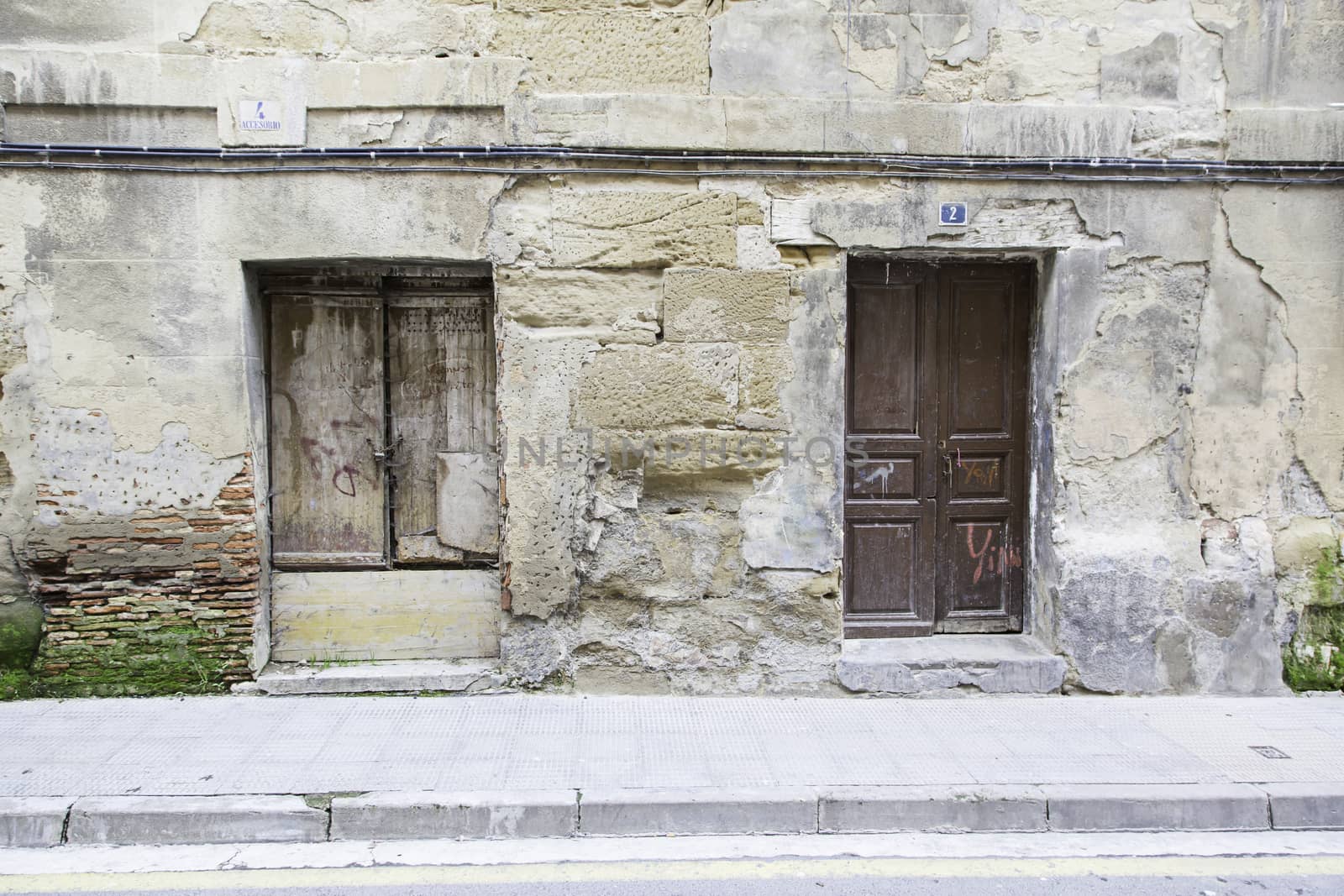 Old wooden door wall, detail of a building in ruins and abandoned