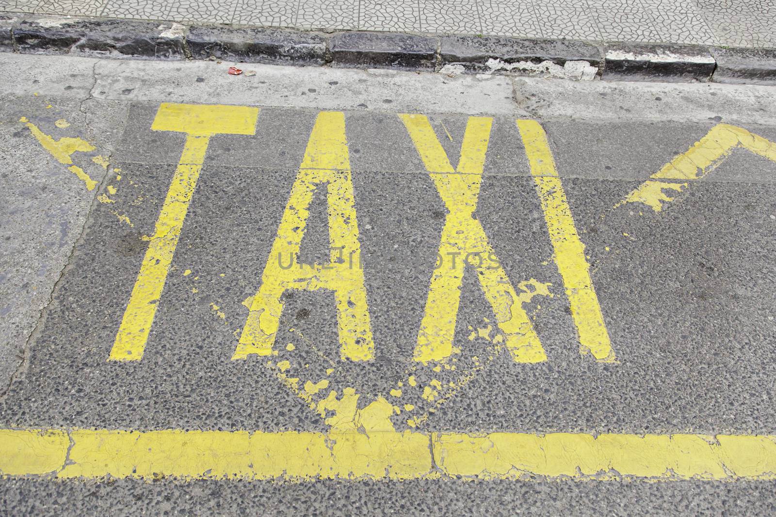 Taxi sign on asphalt, detail of a traffic signal, information and tansporte