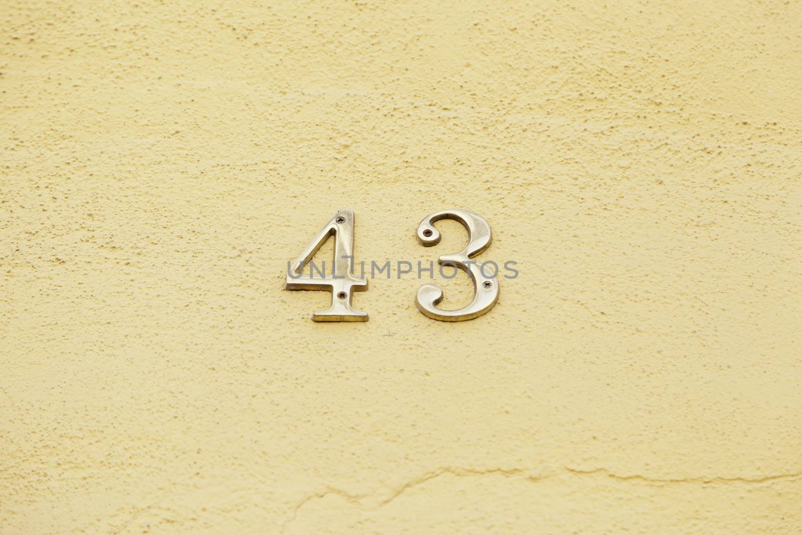 Number forty-three on the wall of a house, detail of a number of information, even number