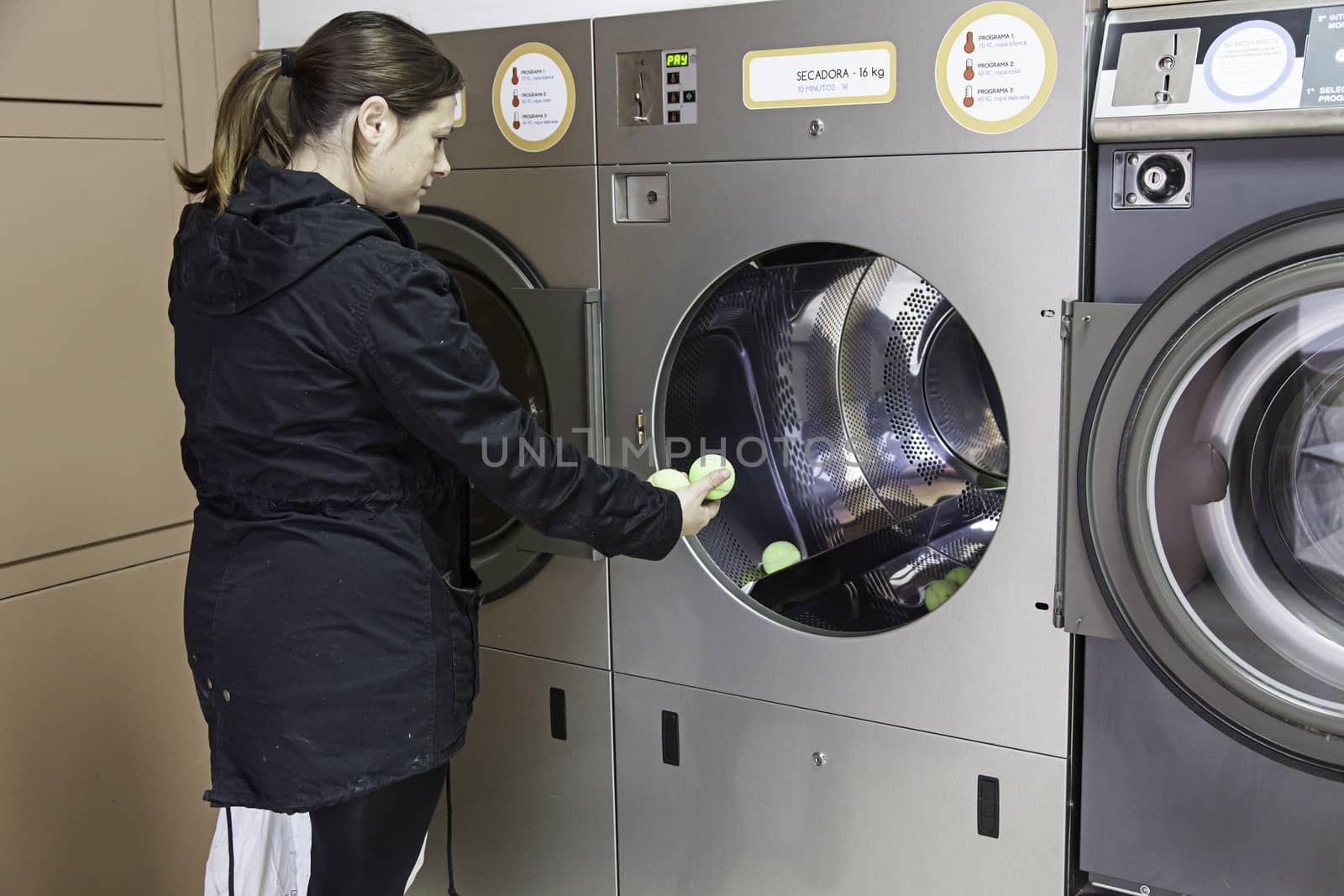 Young woman in a laundry, detail of person washing clothes, cleaning and hygiene