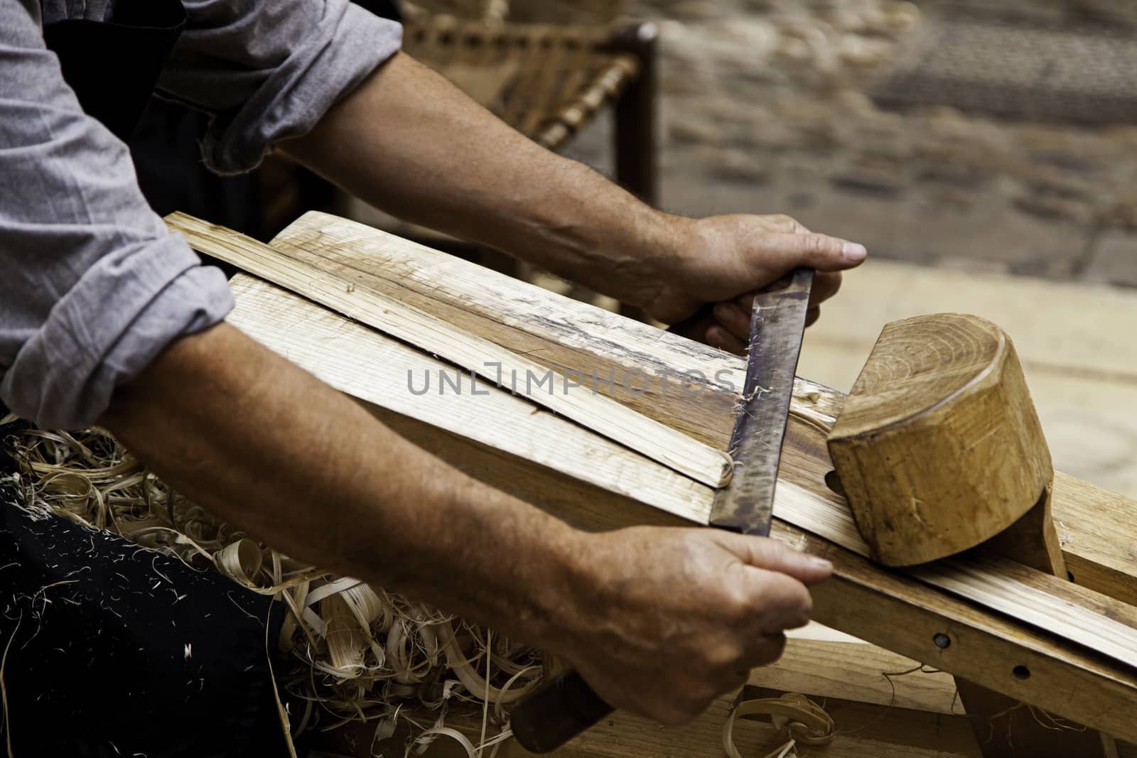 Artisan sanding and shaping wood, detail of craftsman's work