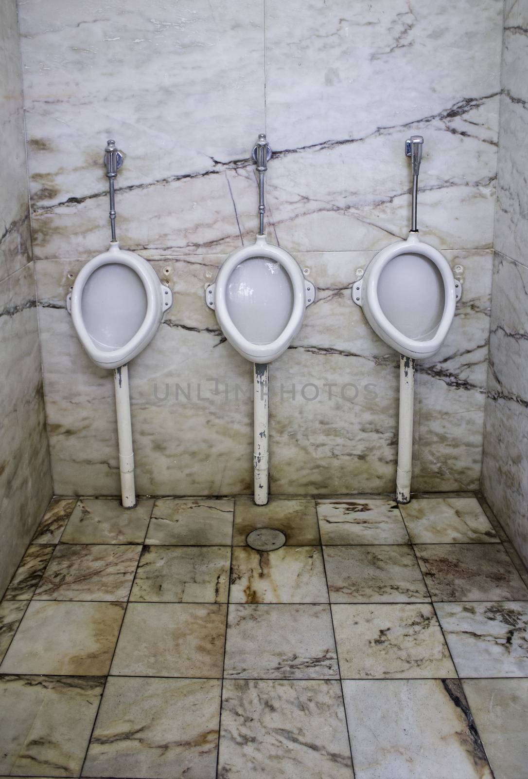 Interior public bathroom in the city, detail of toilet for men, basic necessities