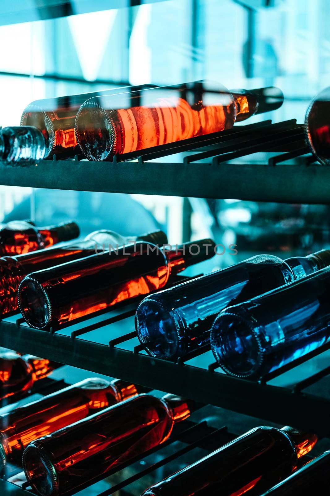 Rows of colourful wine bottles, Detail image of Metal rack with plenty of wine bottles composed in rows for decor.