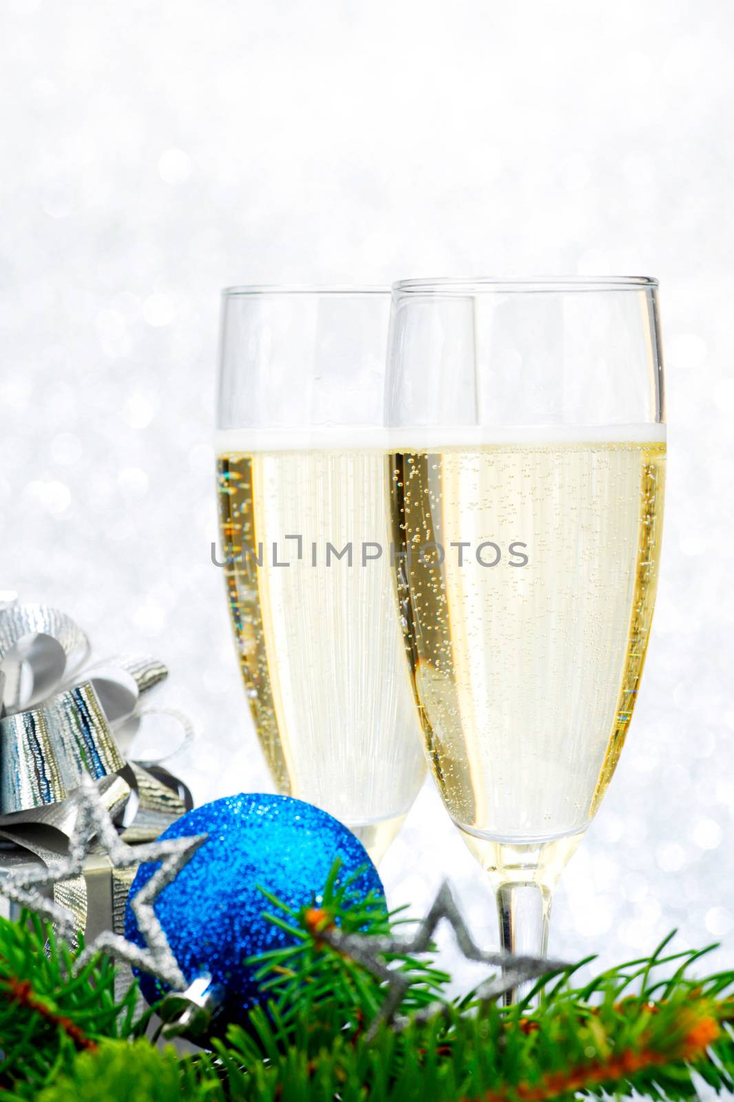 Champagne, firtree and christmas decor on light silver background