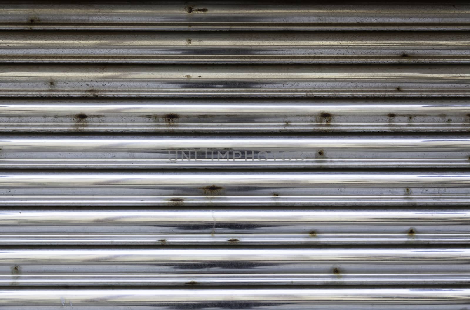 Closed rusty metal door, detail of a metallic textured background, safety and security