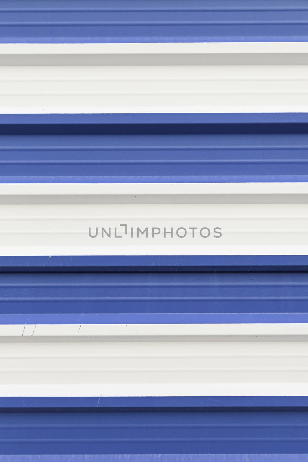 Metal wall painted white and blue, detail of a wall decorated with metallic colors, textured background