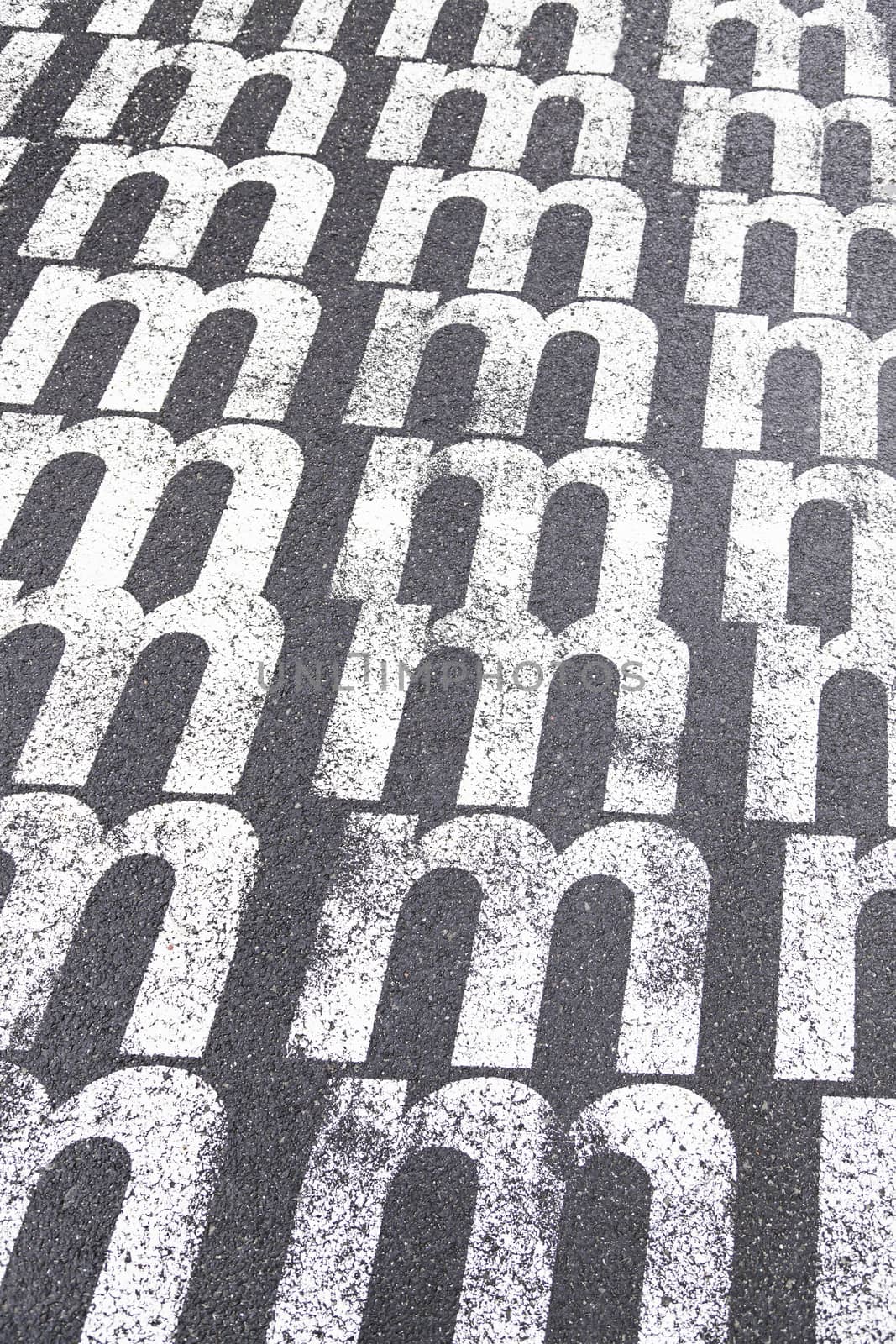 Letter m painted on the floor, detail of a letter on the Asphalt, signal information