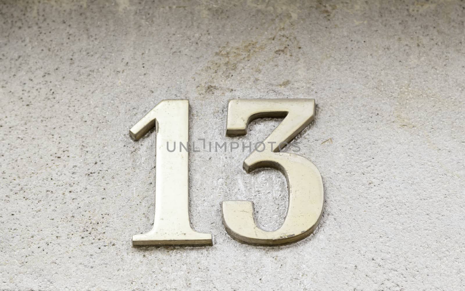 Number thirteen on a wall, detail of house numbers on figures