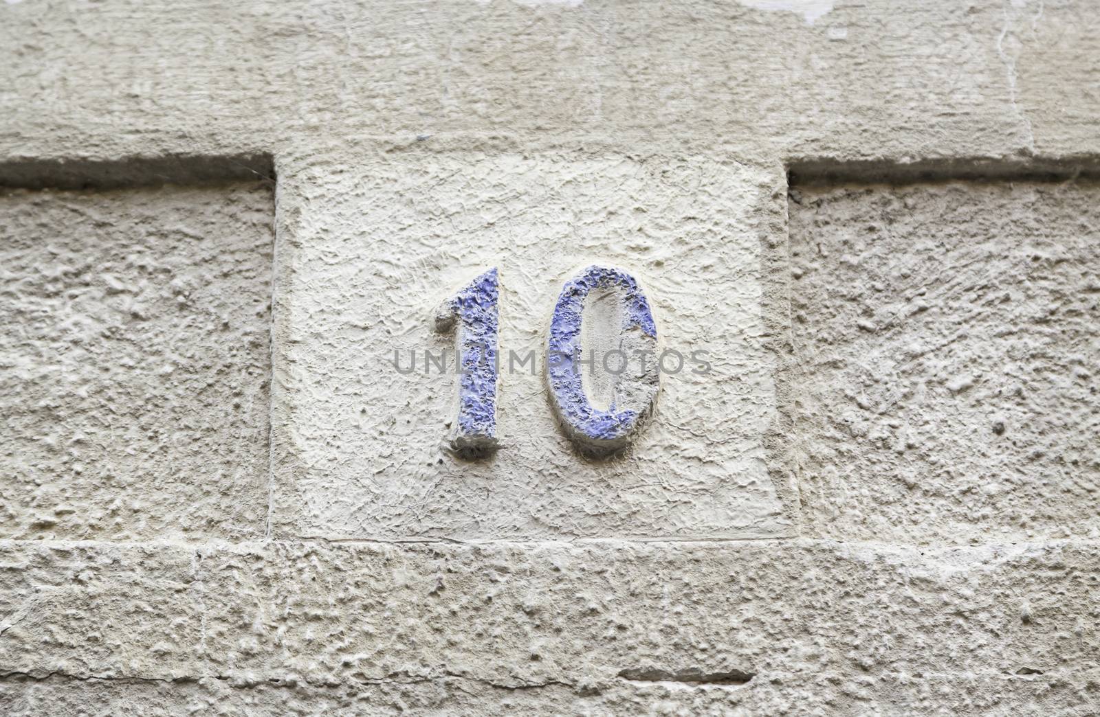 Number ten on a stone wall, detail of a number of information on a wall in the city, ancient and old