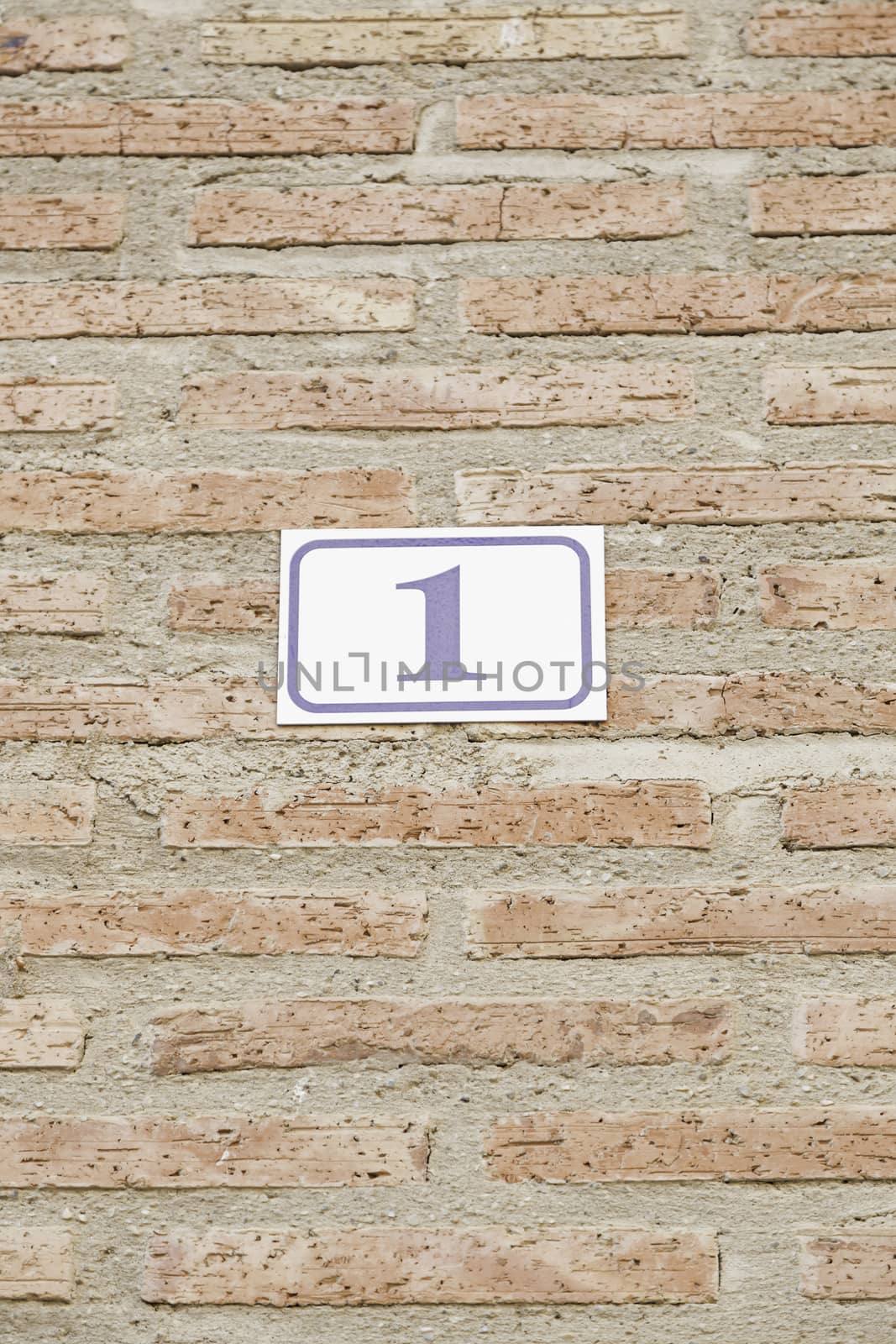 Number one in a brick wall, detail of a number on a wall in a house, information