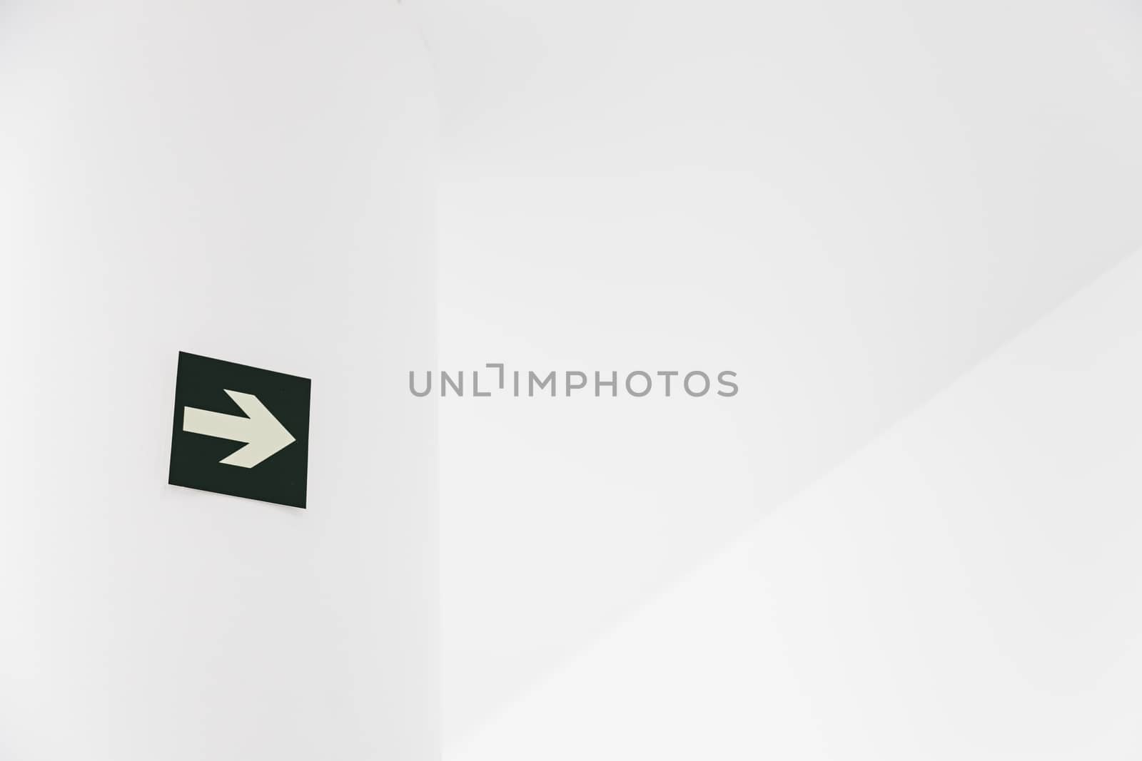 Green Arrow departure, detail of an arrow on a white wall, and safety information