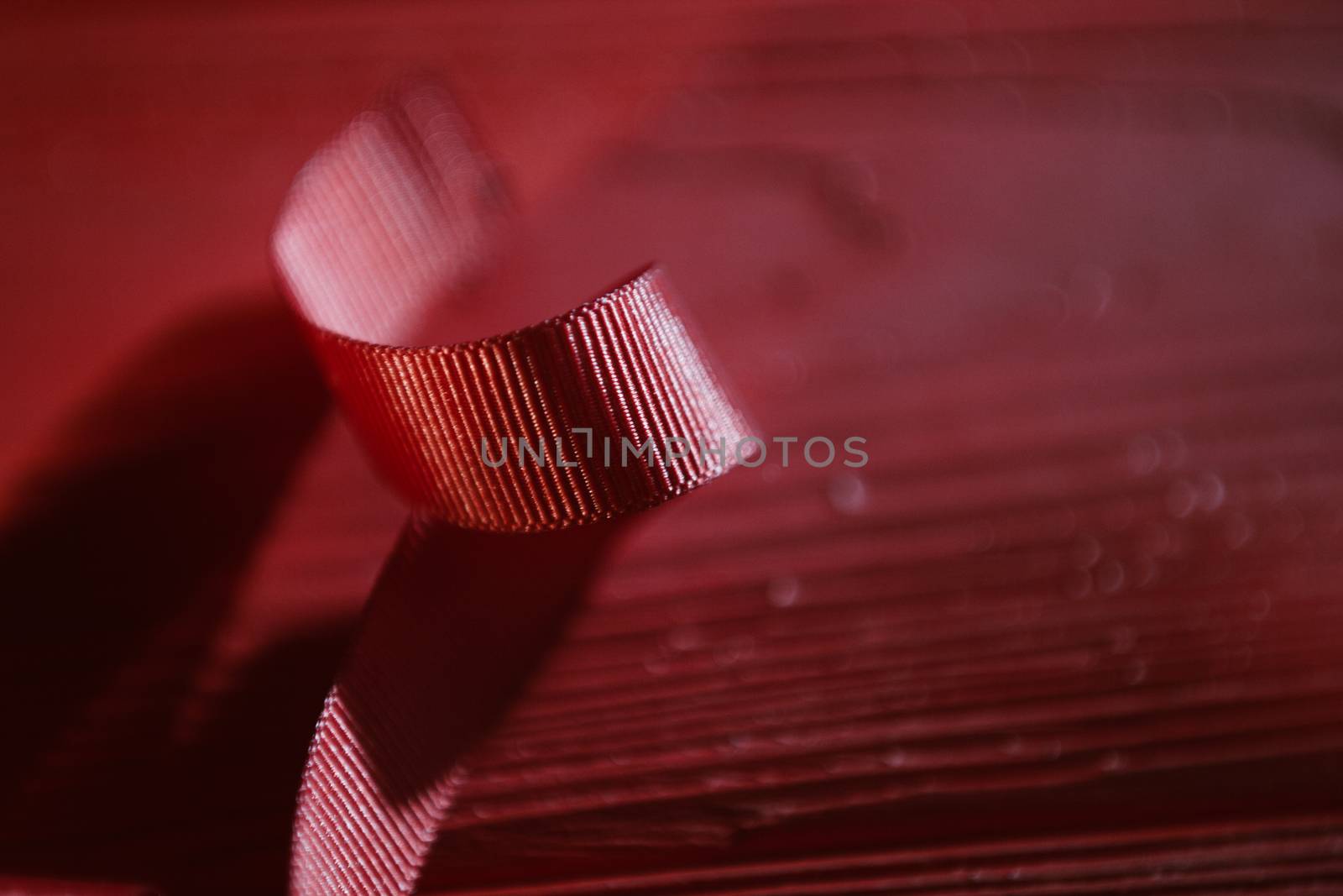 Red ribbon on red wooden table background. Flat lay