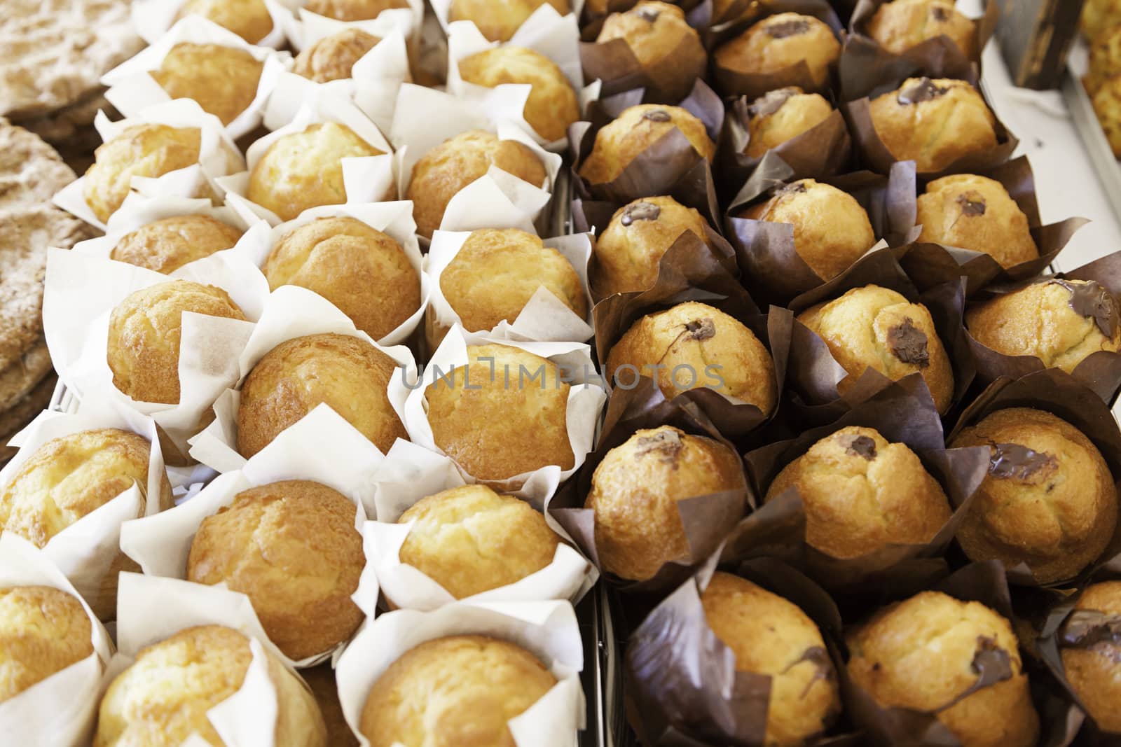 Homemade cupcakes in a market, detail of normal muffins and chocolate dessert