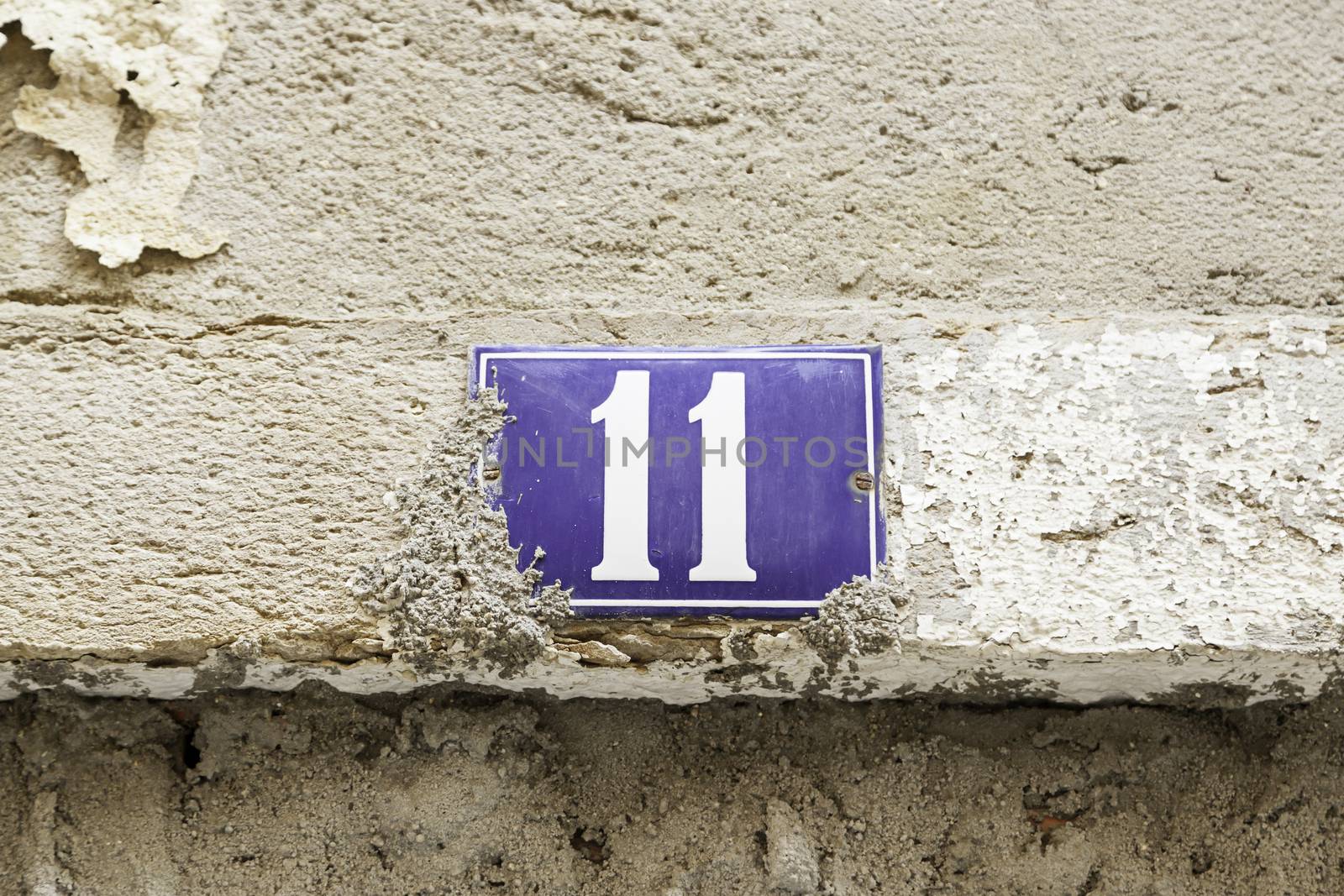 Number eleven on a wall, detail of a number of information in a house