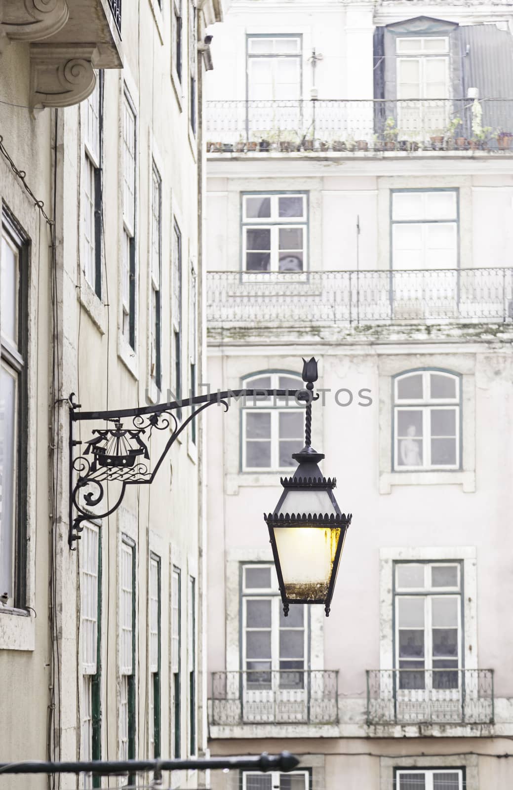 Old street lamp on a classical facade in Lisbon, detail of an old lighting in the city, Art and Tourism