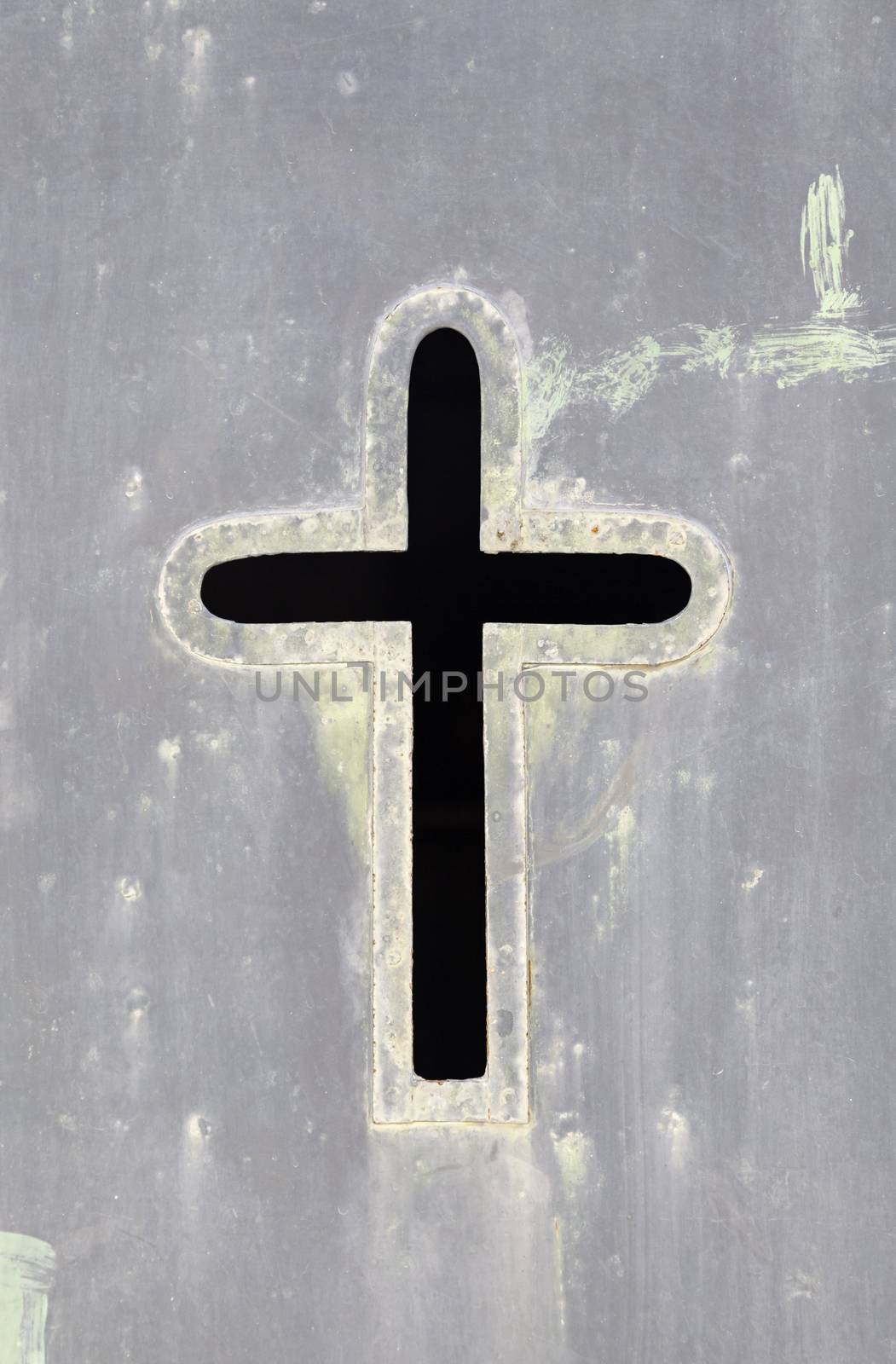 Old rusty metal cross, detail of an old cross on a metal wall, cemetery