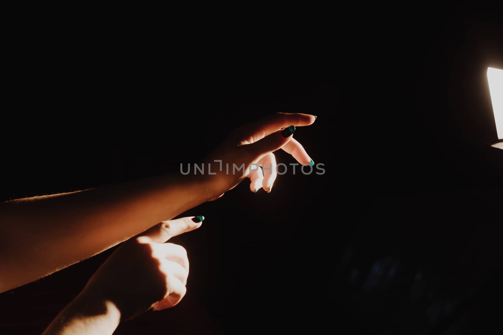 girl reaching for the light of the lantern, wooman in a dark room. illuminated hands by yulaphotographer