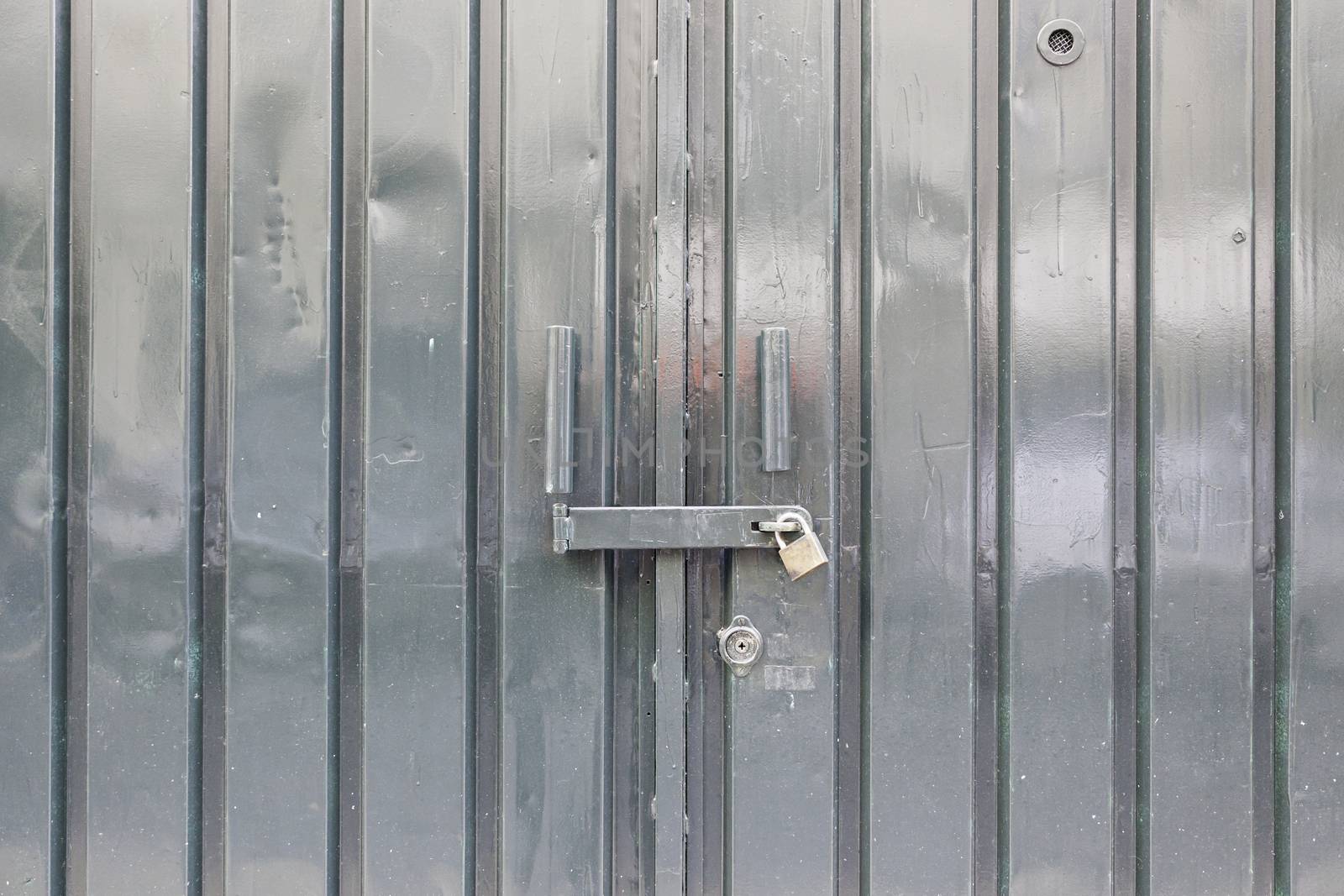 Bright green metal door, detail of a closed door, protection and security
