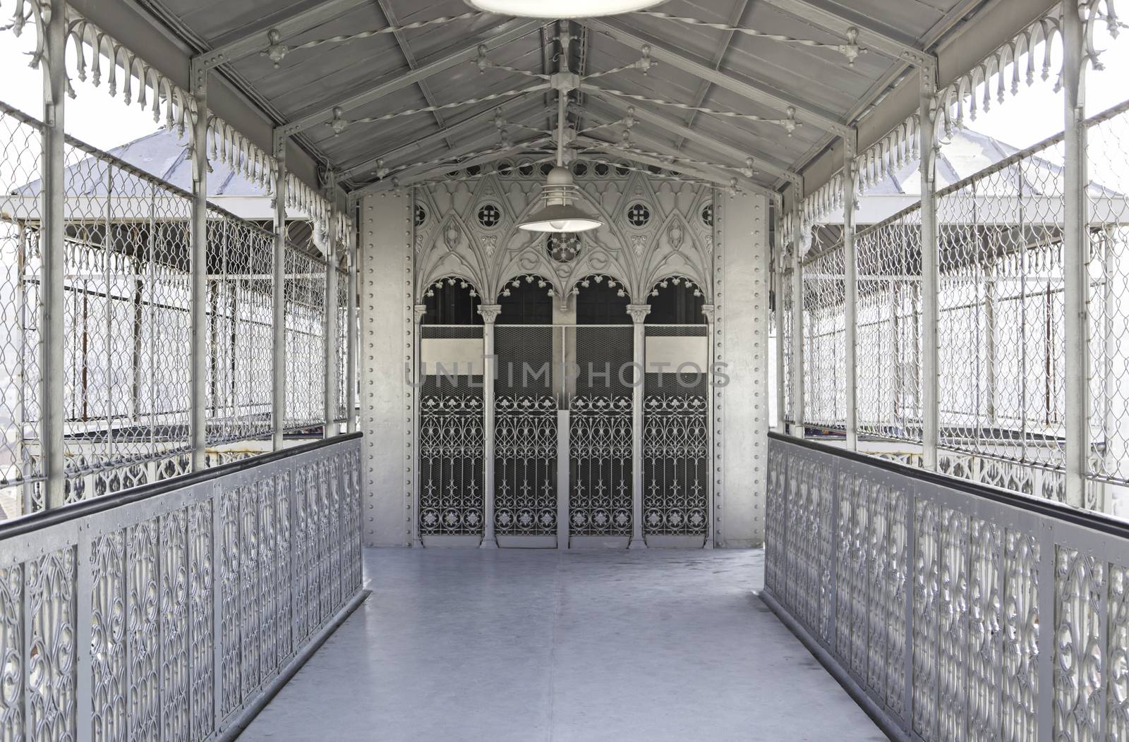 Metallic and deep corridor, detail of a hall with elevator to the background, old