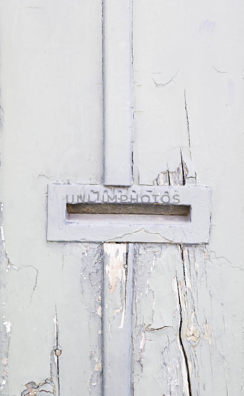 Abandoned gray wooden door with mailbox, detail of an old door damaged on the street