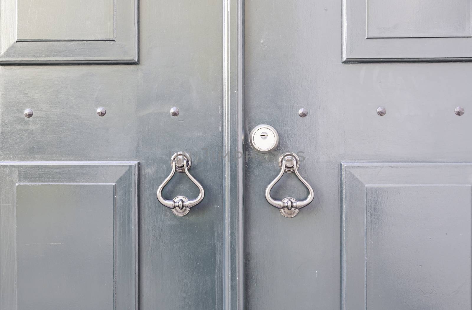 Wooden door with metal knockers, door detail of a decorated, safety and security