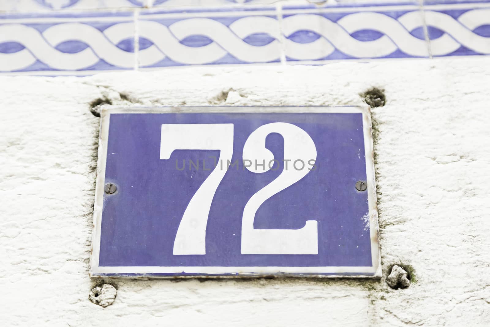 Number seventy-two on a wall, detail of a number of information on a plate in a house