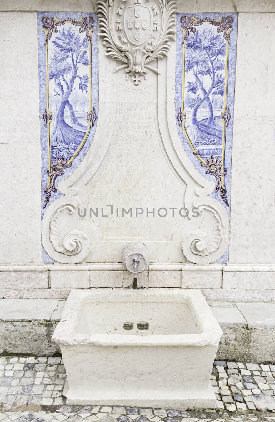 Old stone fountain, detail of a fountain with decorative tiles, ancient monument
