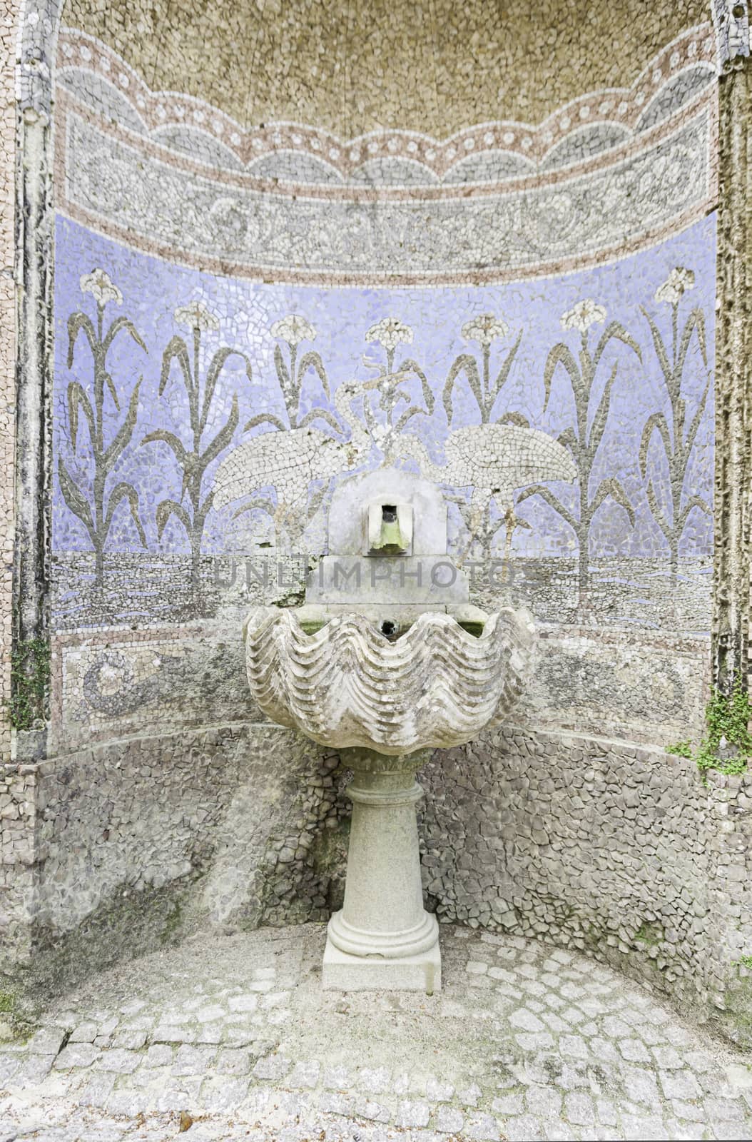 Old fountain with stone mosaics, detail of a water fountain, ancient art