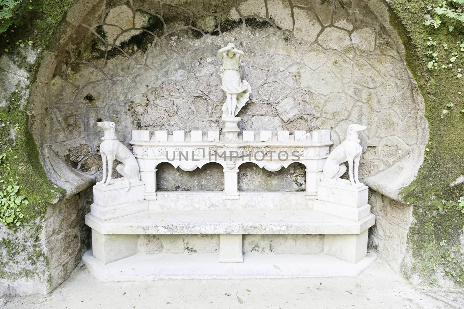 Detail of a stone bench with statues, ancient art in a garden of Portugal