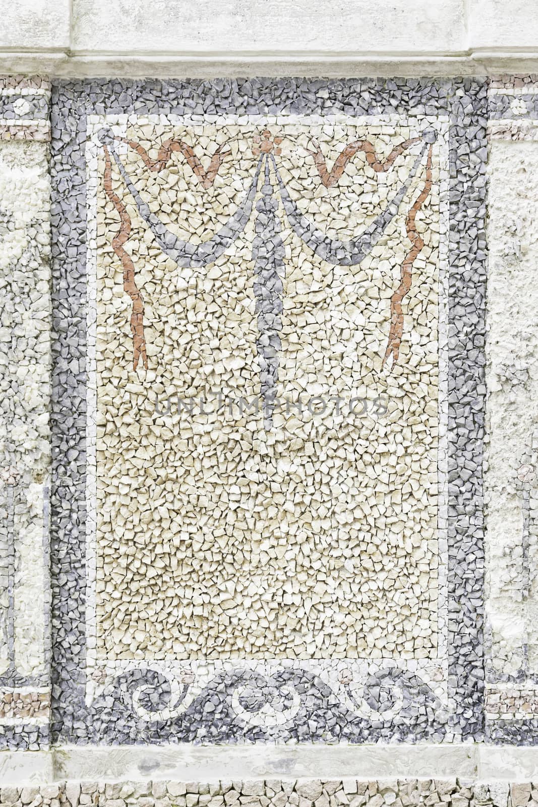 Old stone mosaic, detail of a wall decorated with colored stones, textured background