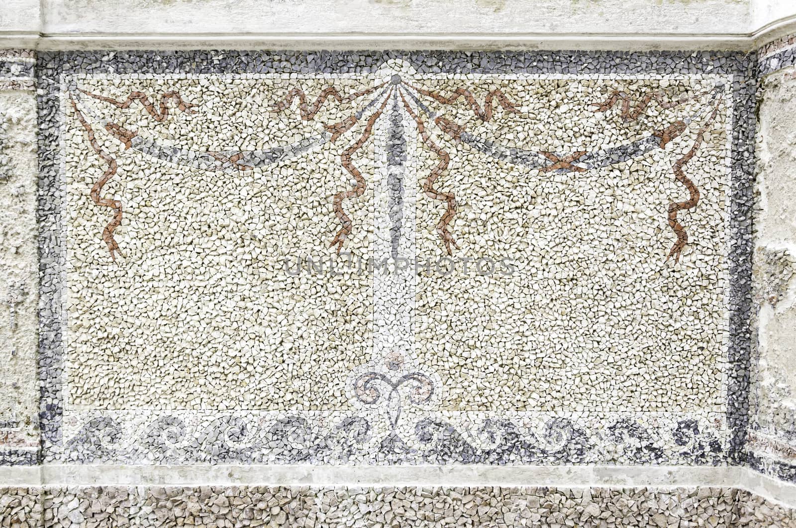 Old stone mosaic, detail of a wall decorated with colored stones, textured background