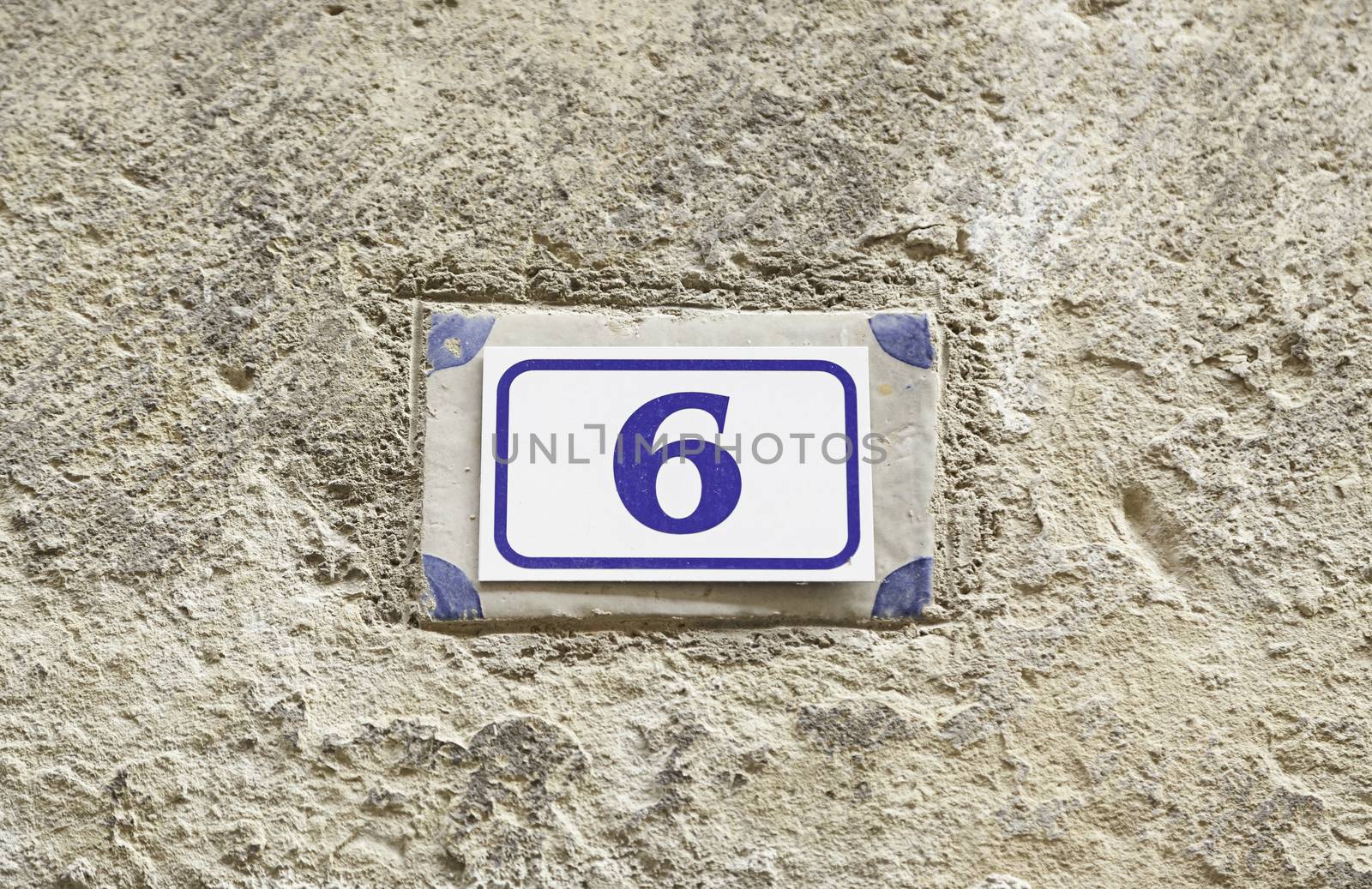 Number six on a wall, detail of a number of information on a wall of a house, even number